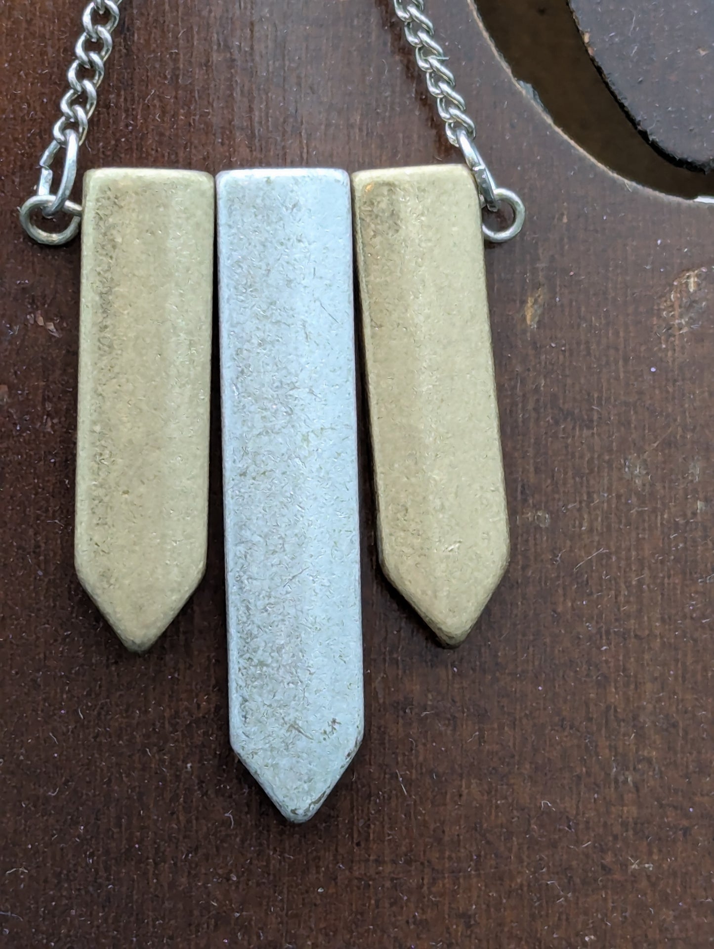 Close-up of a pair of earrings with metallic pendants.