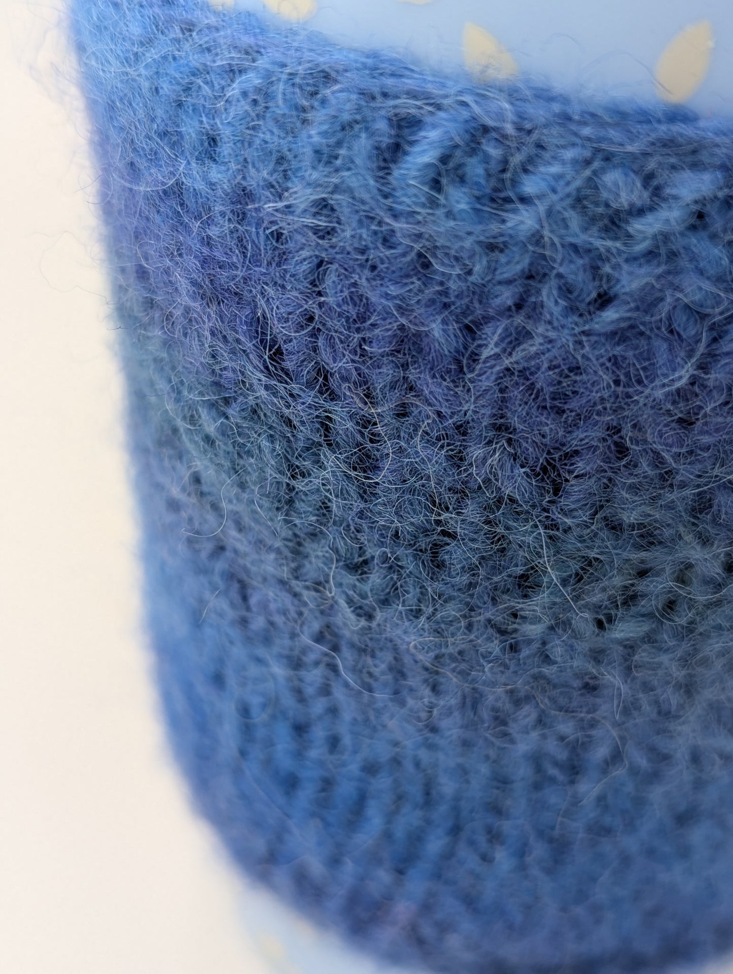 Close-up of a blue knitted and felted mug cozy
