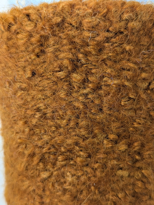 Close-up of a brown knitted and felted mug cozy