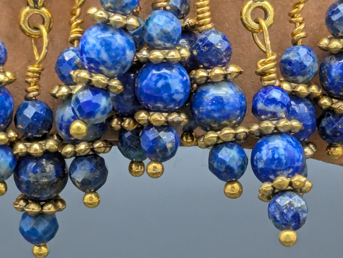 Close up of ornate blue and gold earrings.