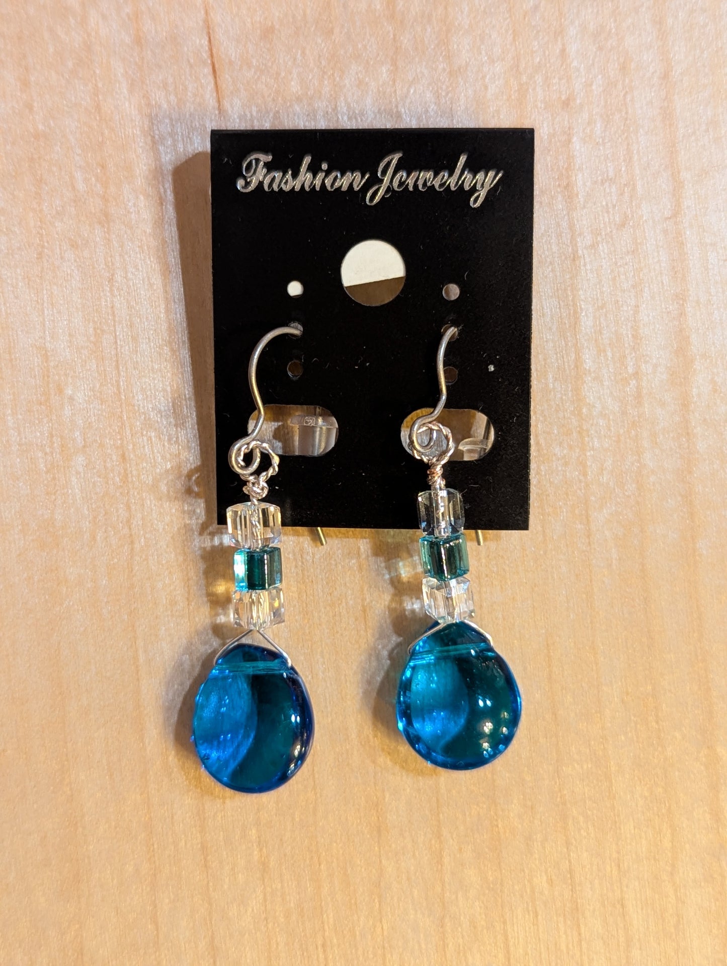 Dangle earrings on silver hooks. clear and blue Swarovski crystals lead down to a luminous smooth blue crystal droplet.