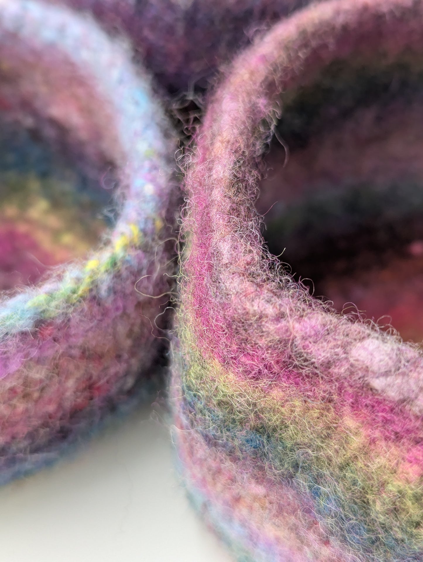 Close-up of three heather flower colored felted bowls