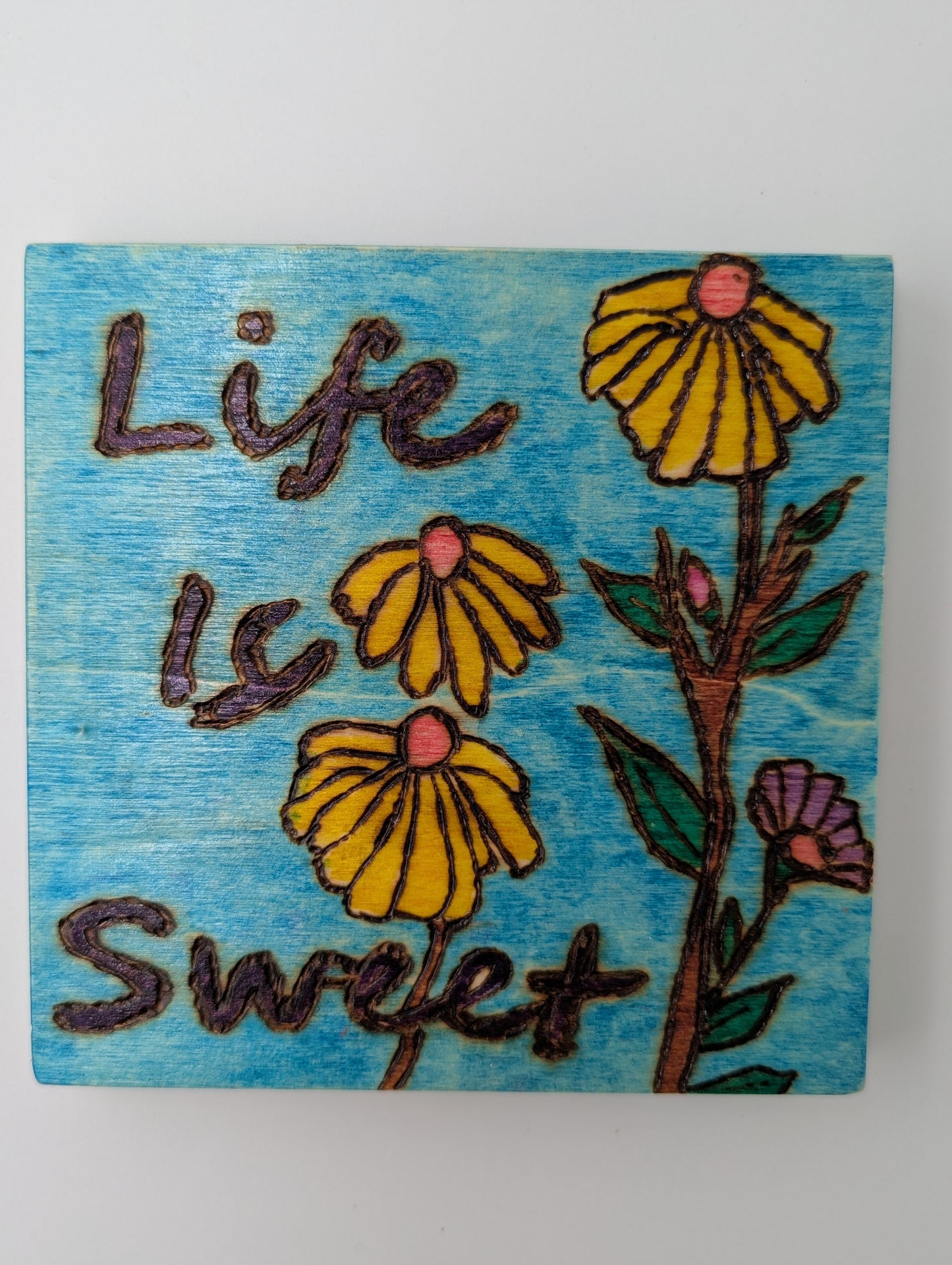 Original wooden wall art. Wood-burned and hand painted with 'Life is Sweet' and yellow flowers on a blue background.