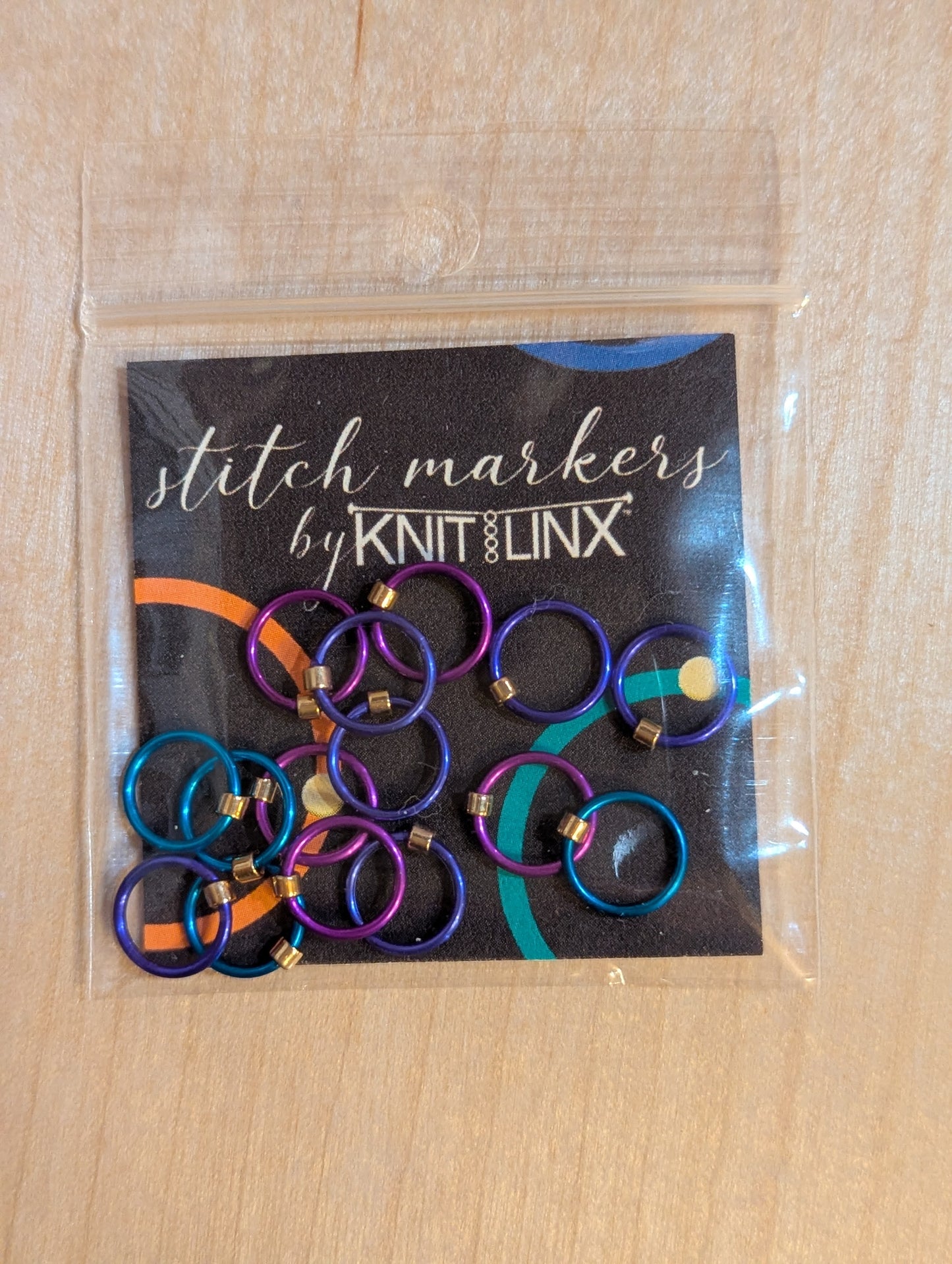Knitting or crocheting stitch markers by KnitLinx for knitting needles size 0 through 8. Made from metal in purple, blue and teal colors.