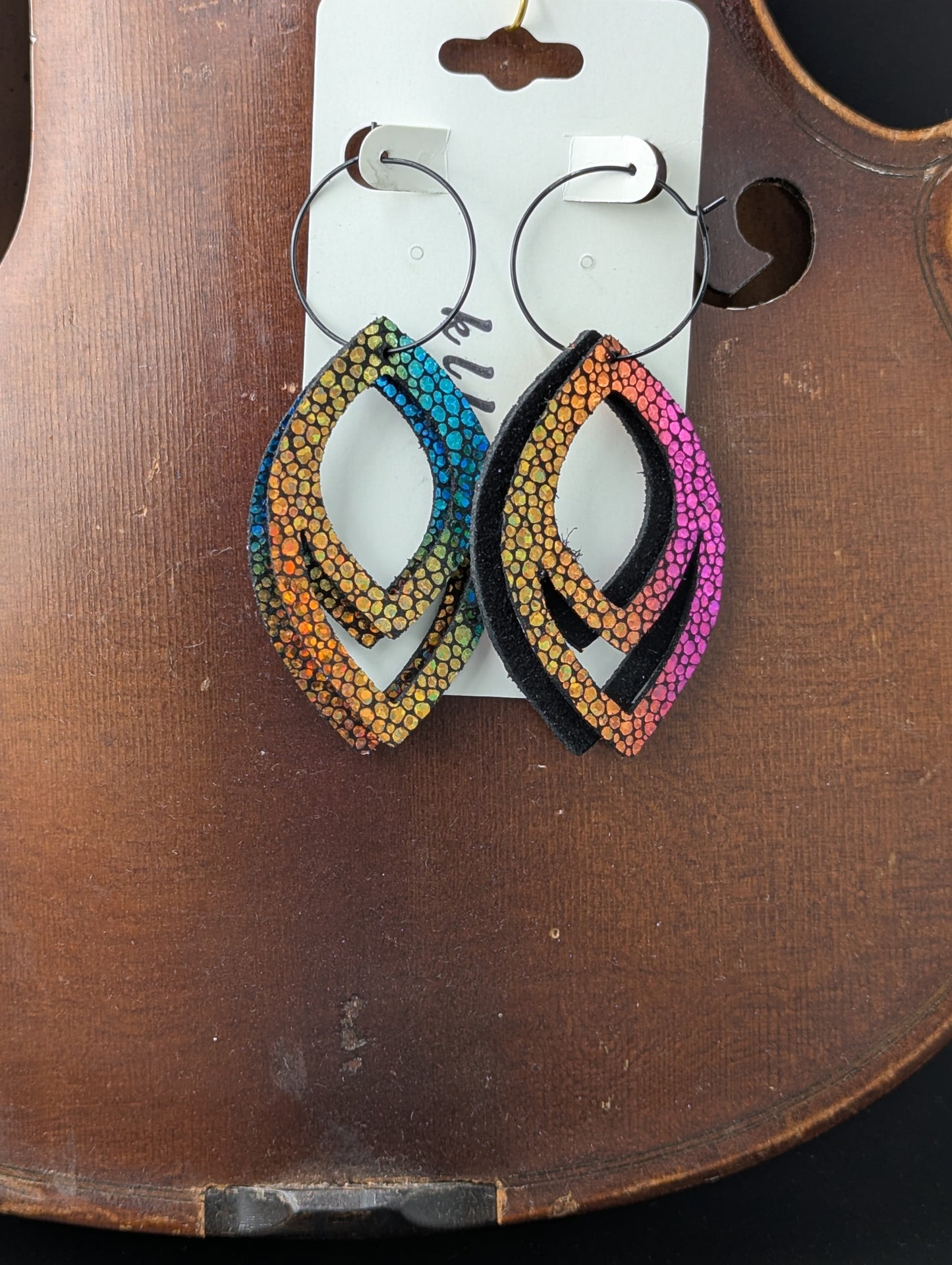 Deep iridescent drop shaped leather earrings on black hoops. 3 inches long.