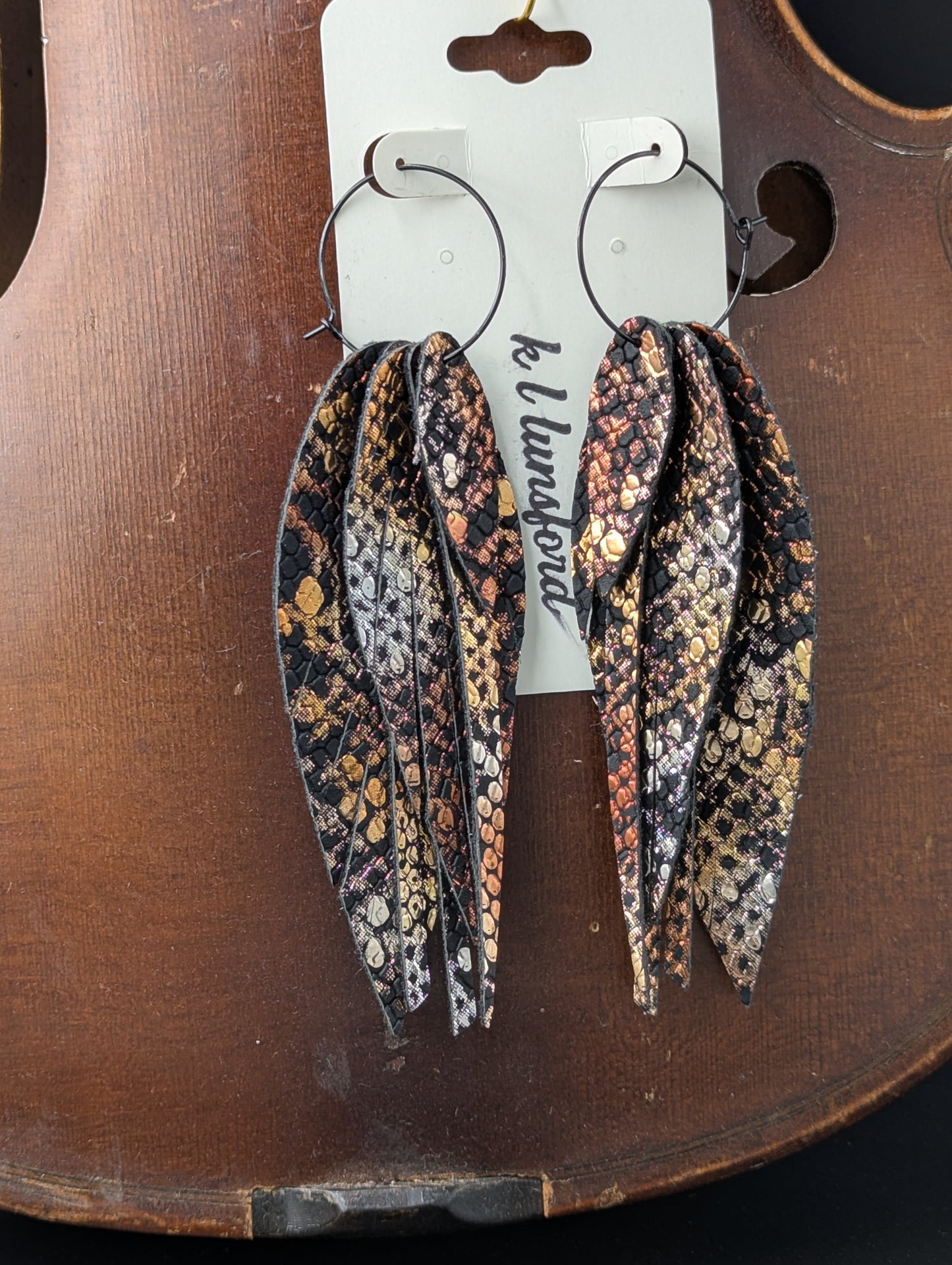 Leather earrings. Feather shaped, black and shiny metallic bronze with black hoops. 4.5 inches long.