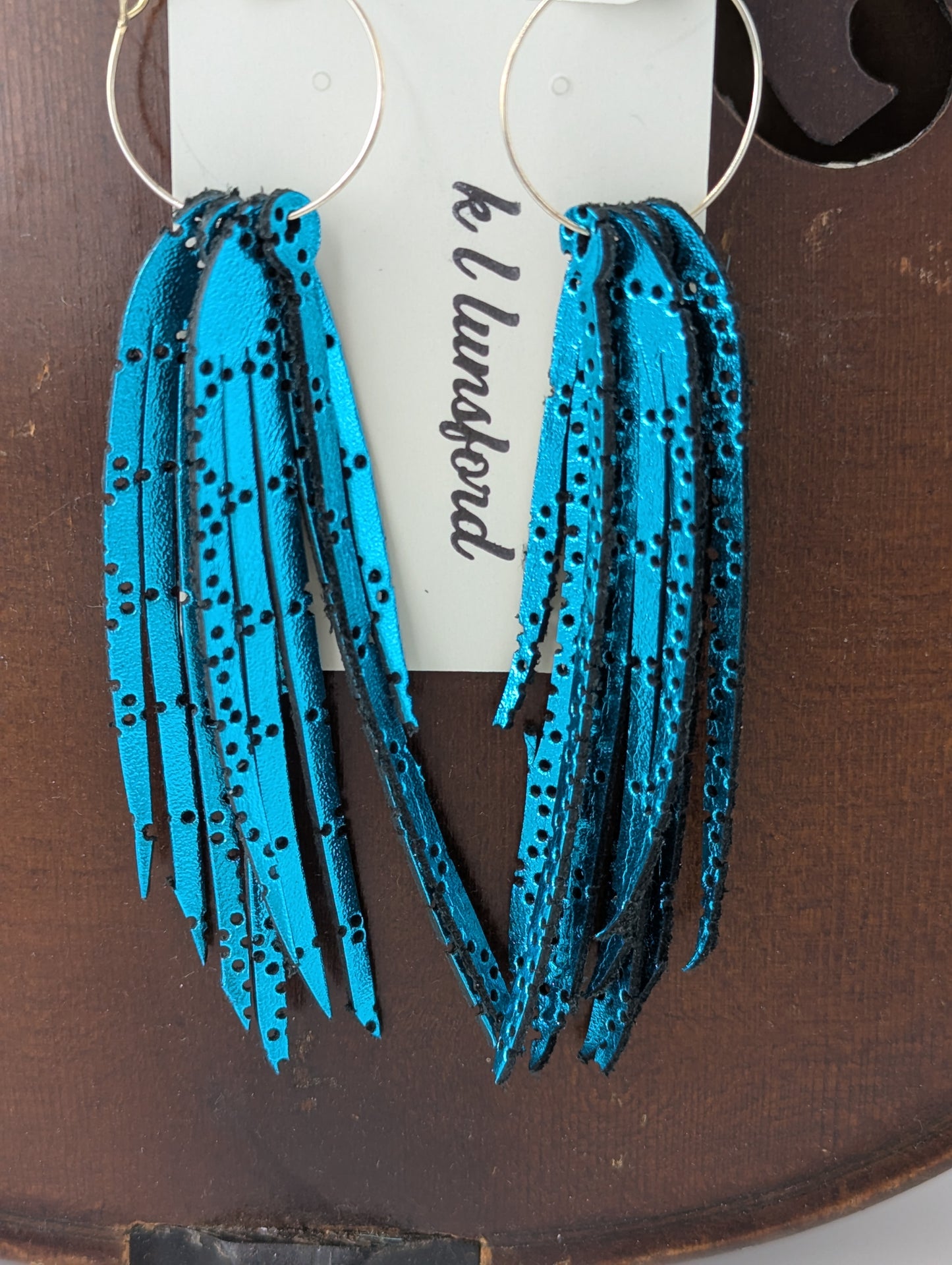 Leather earrings. Shimmery turquoise strands with delicate holes. 4.5 inches long.