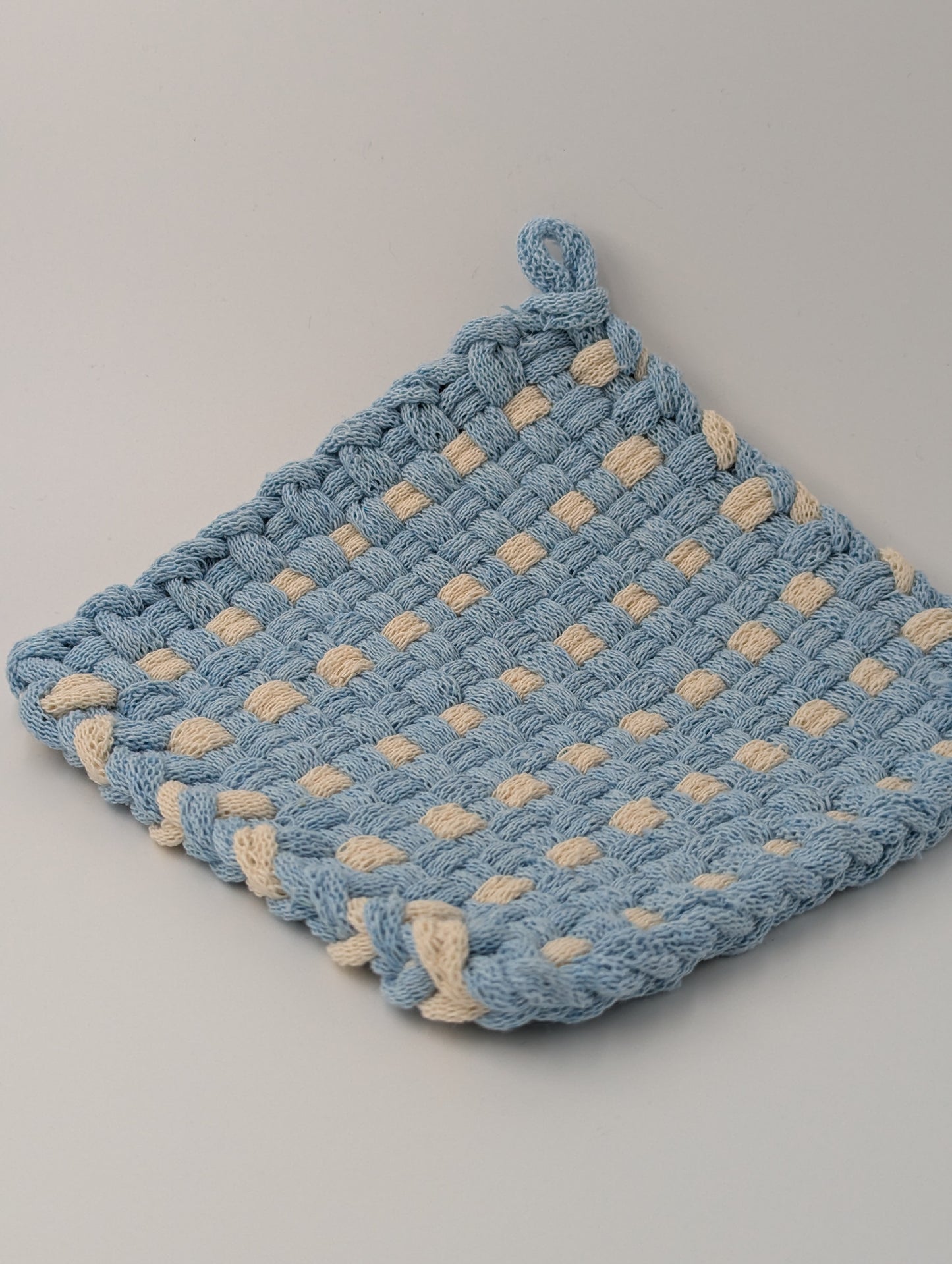 Hand woven pot holder in blue and cream
