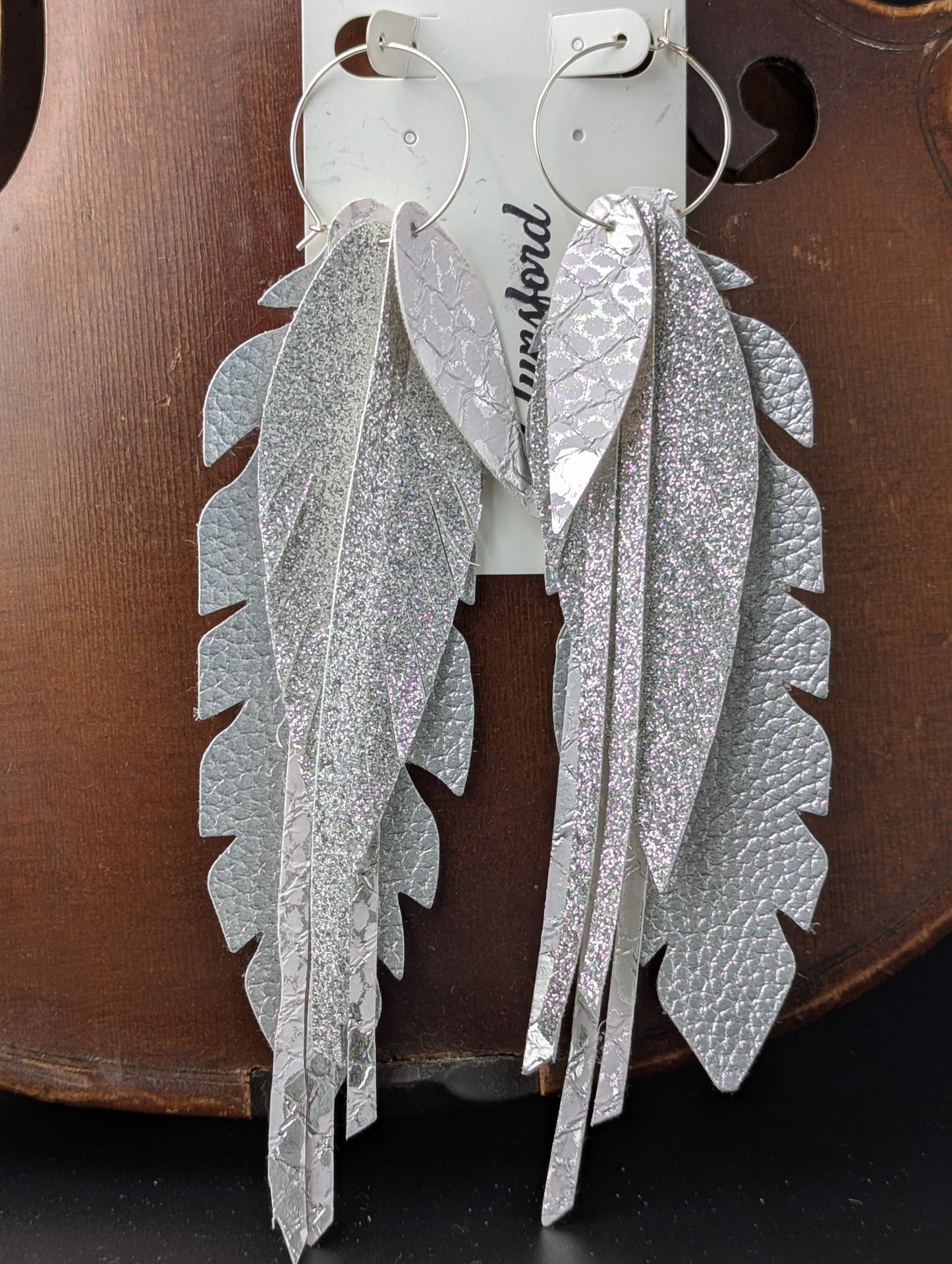 Vegan leather, feather-shaped earrings. Silver and white, 6 inches long.