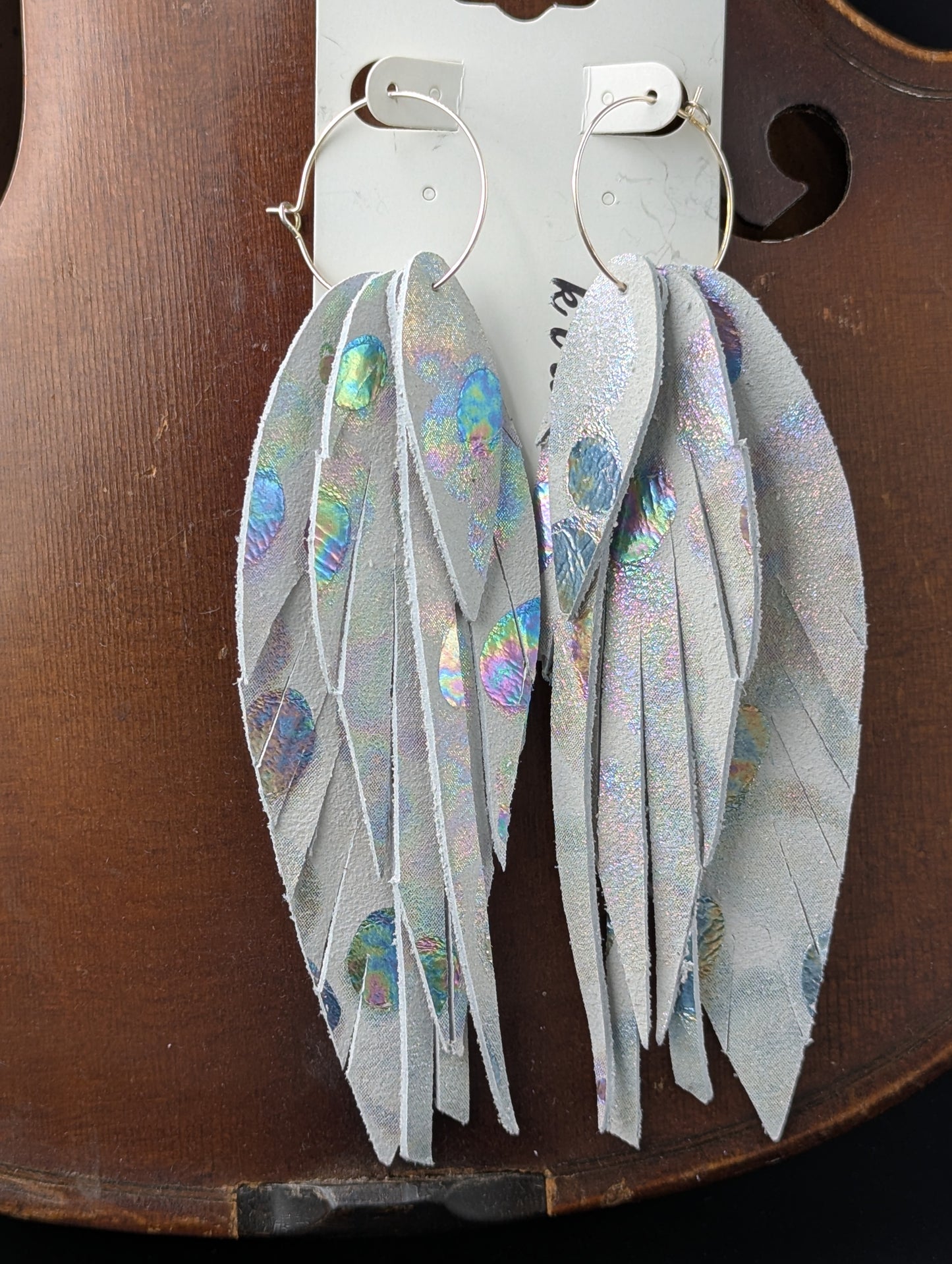 Leather feather shaped earrings with silver hoops. White, gray, and iridescent silver. 5 inches long.