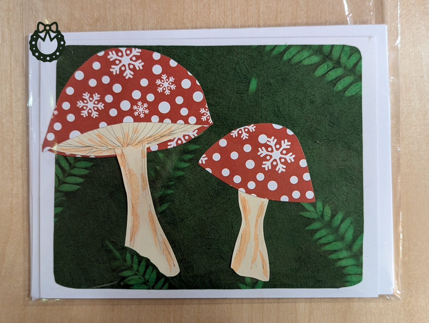 Christmas card with red and white polka dot mushrooms on a green background