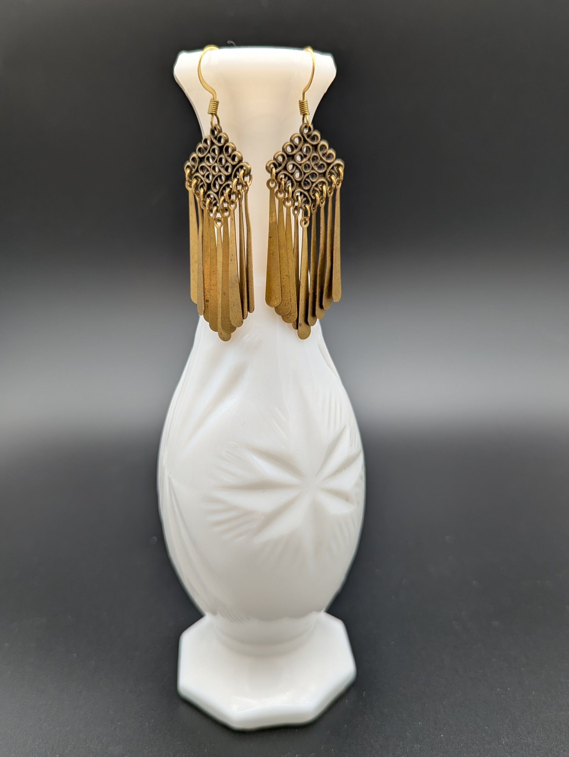 Golden Celtic knot earrings with delicate metal drops. 