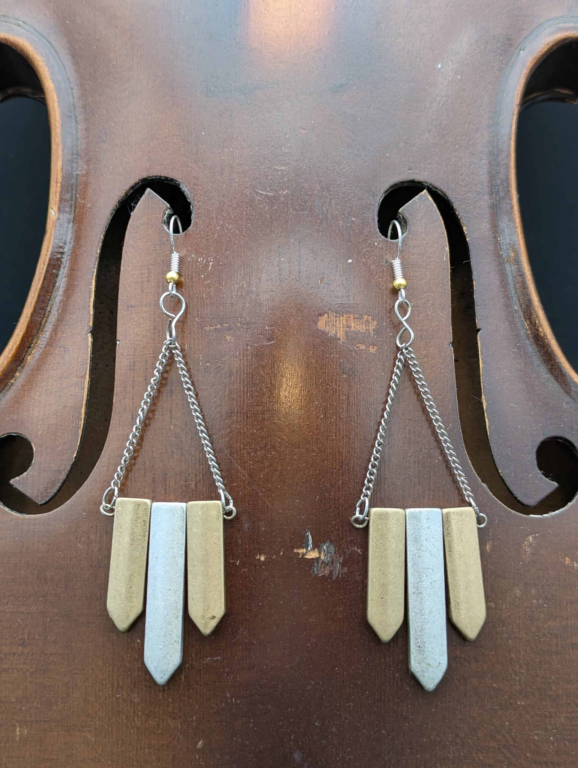 Pair of earrings with metallic pendants. 