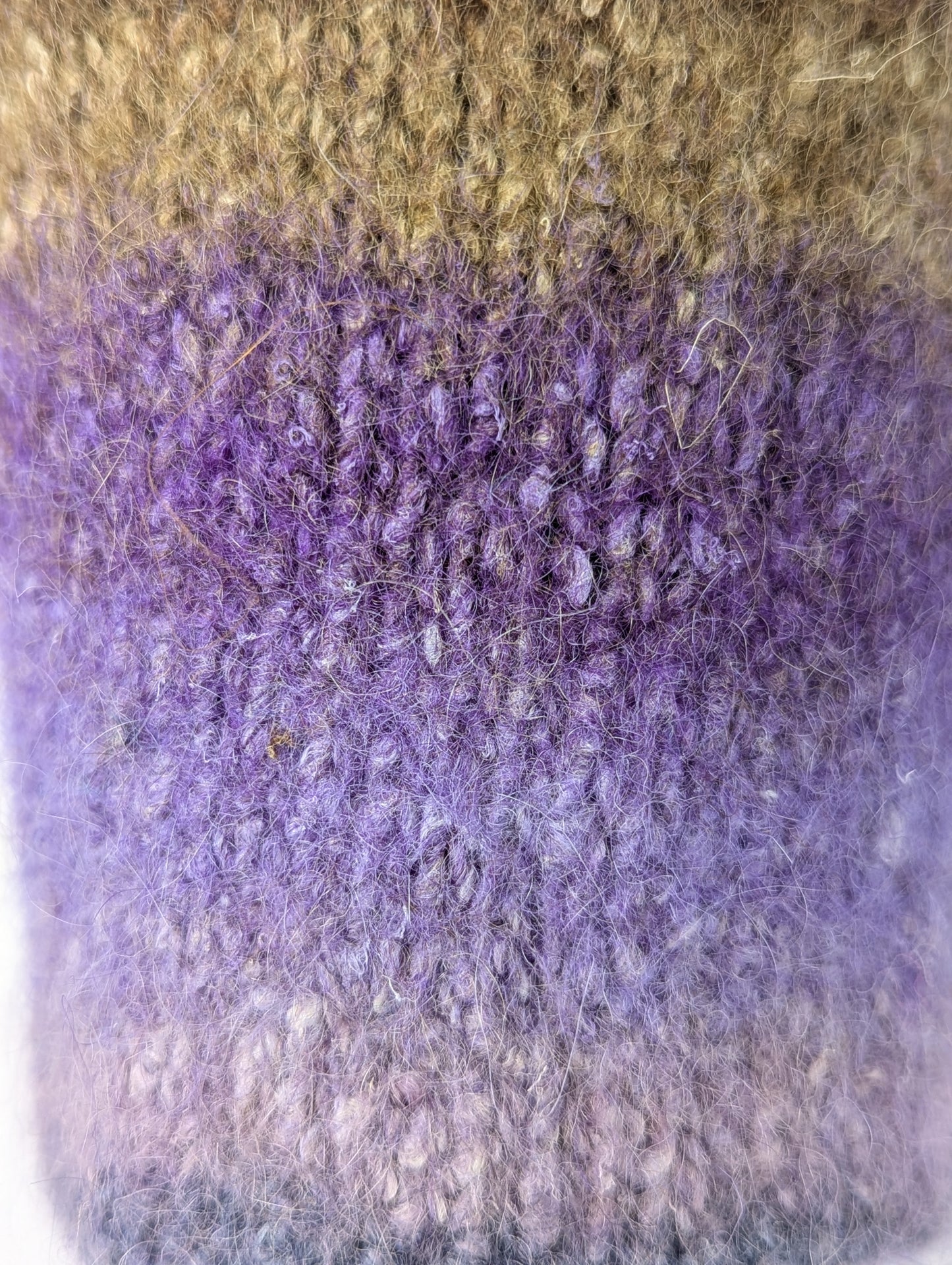 Close-up of a mug cozy with a brown to purple color gradient
