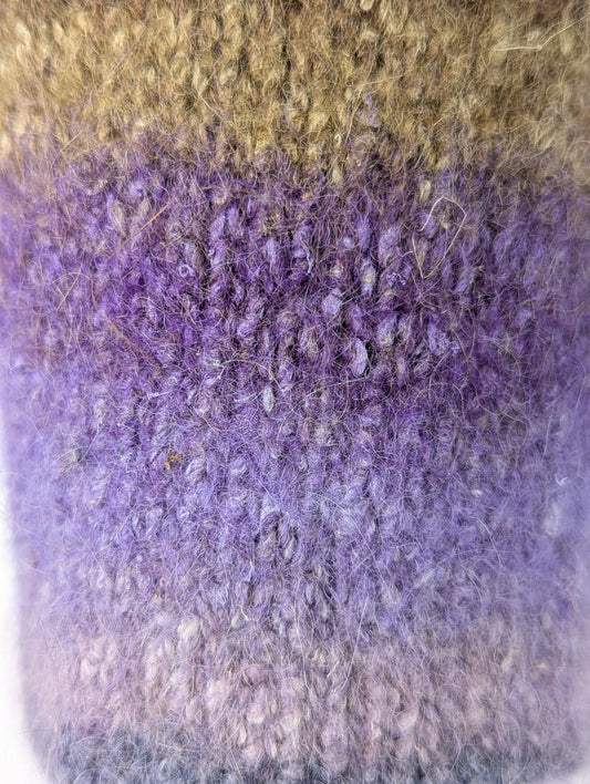 Close-up of a mug cozy with a brown to purple color gradient