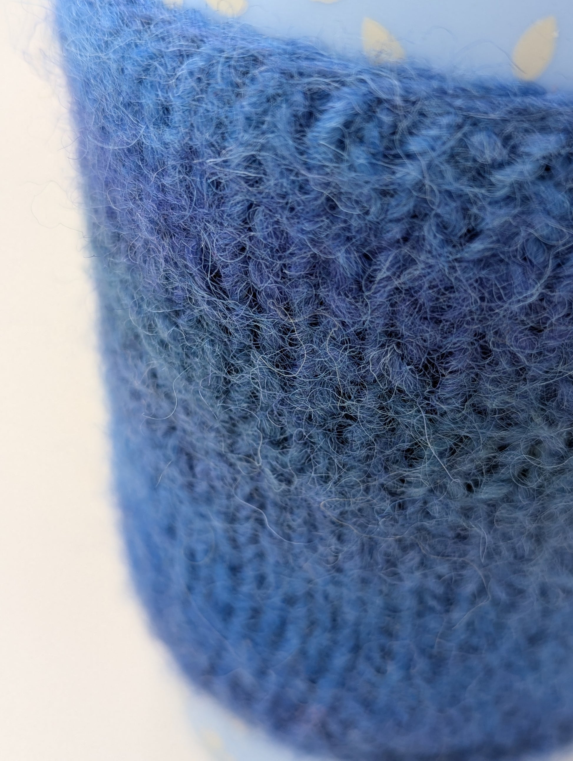 Close-up of a blue knitted and felted mug cozy