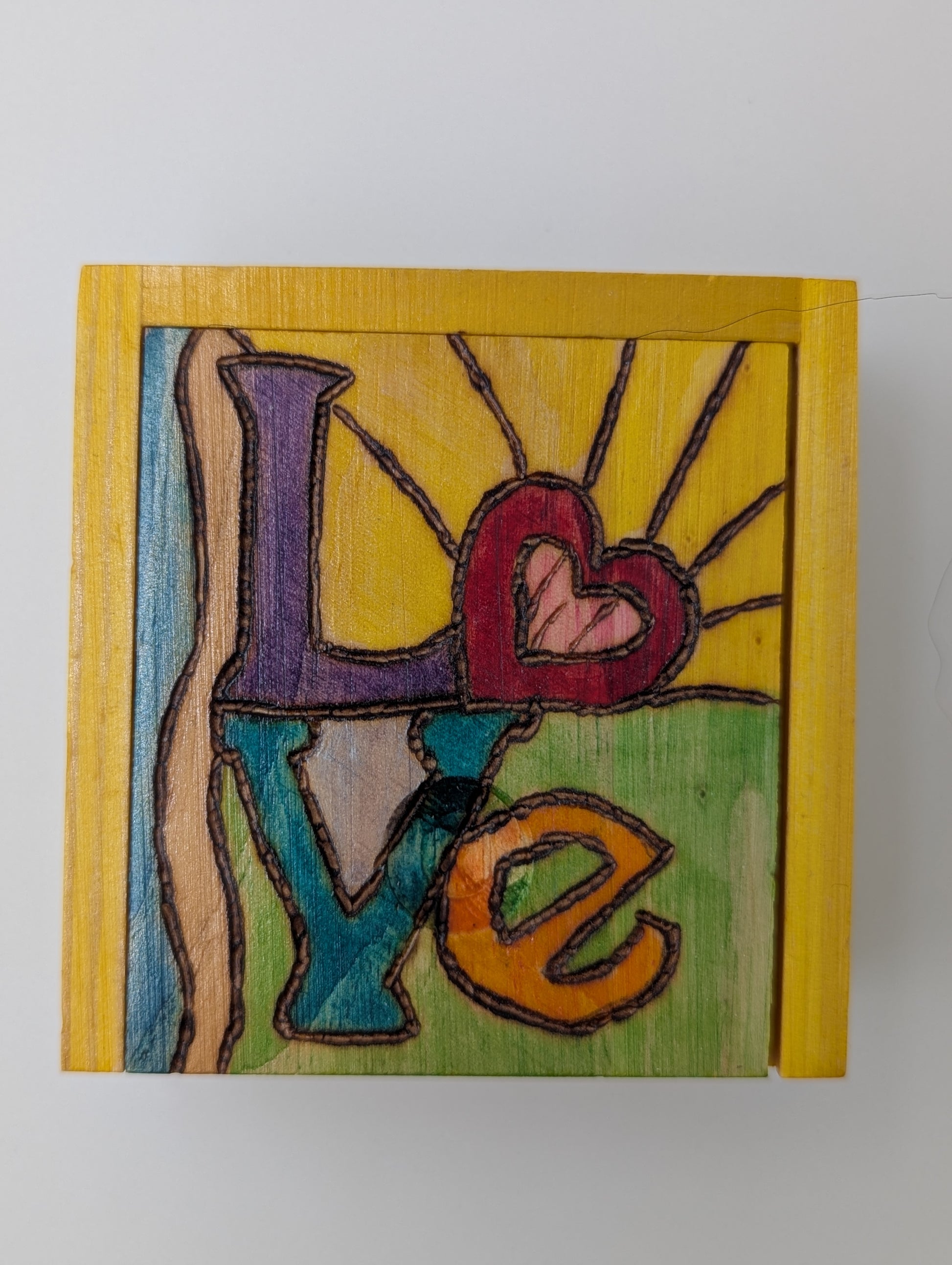 Wood-burned and hand painted trinket box in vibrant colors with the word 'Love'.