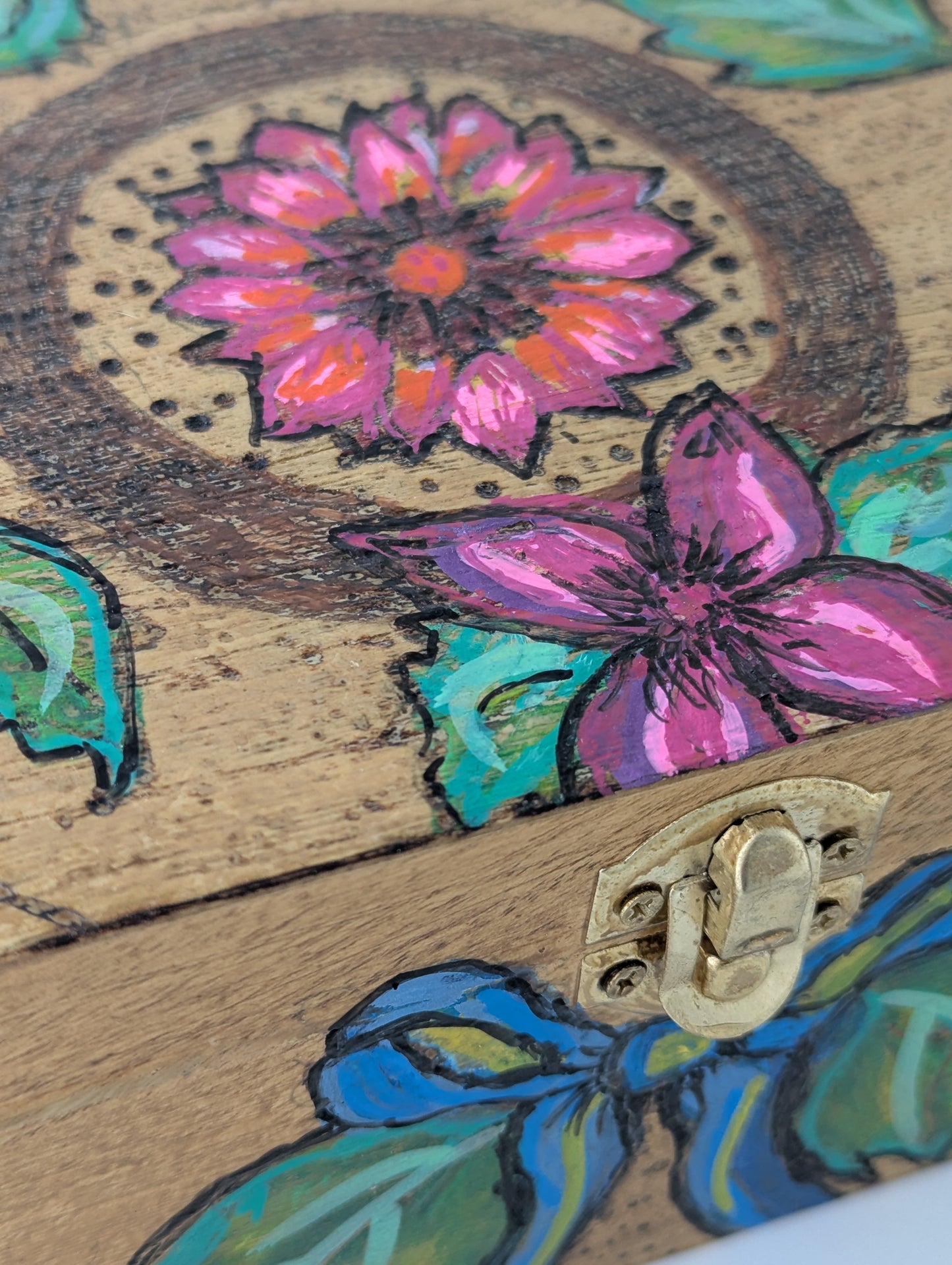 Close up of a wooden box with floral design featuring a dahlia