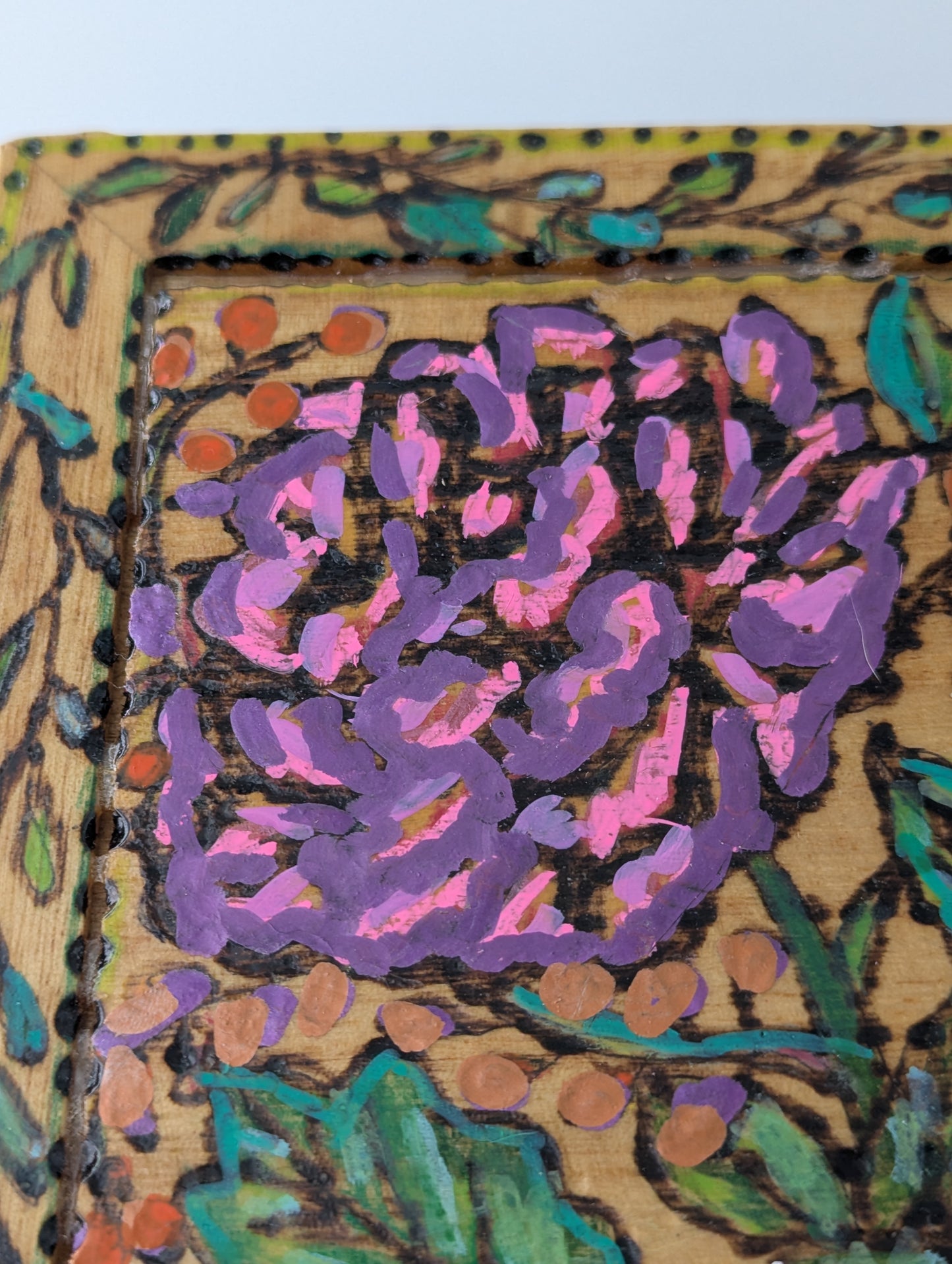 Close up of a decorative wooden box with a rose and floral pattern