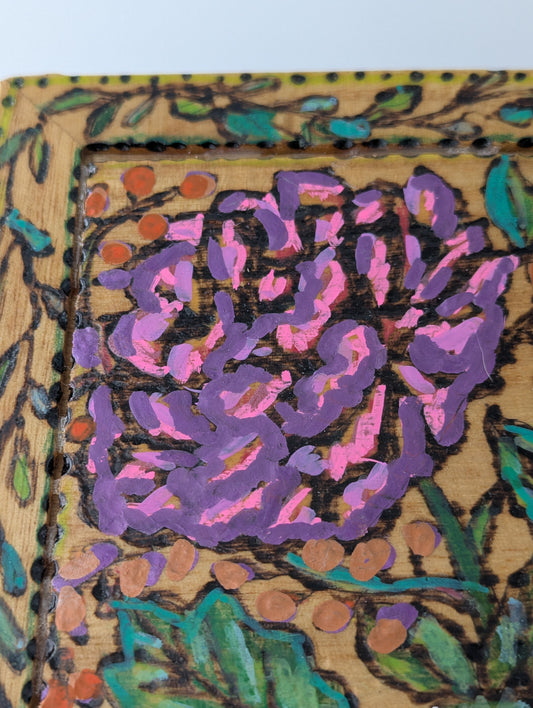 Close up of a decorative wooden box with a rose and floral pattern