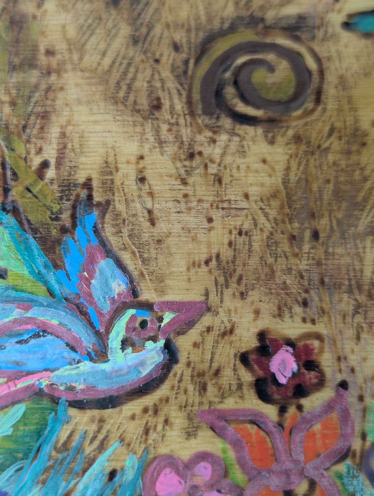 Close up of a decorative wooden box with a springtime design of a tree, birds, butterflies, and flowers 
