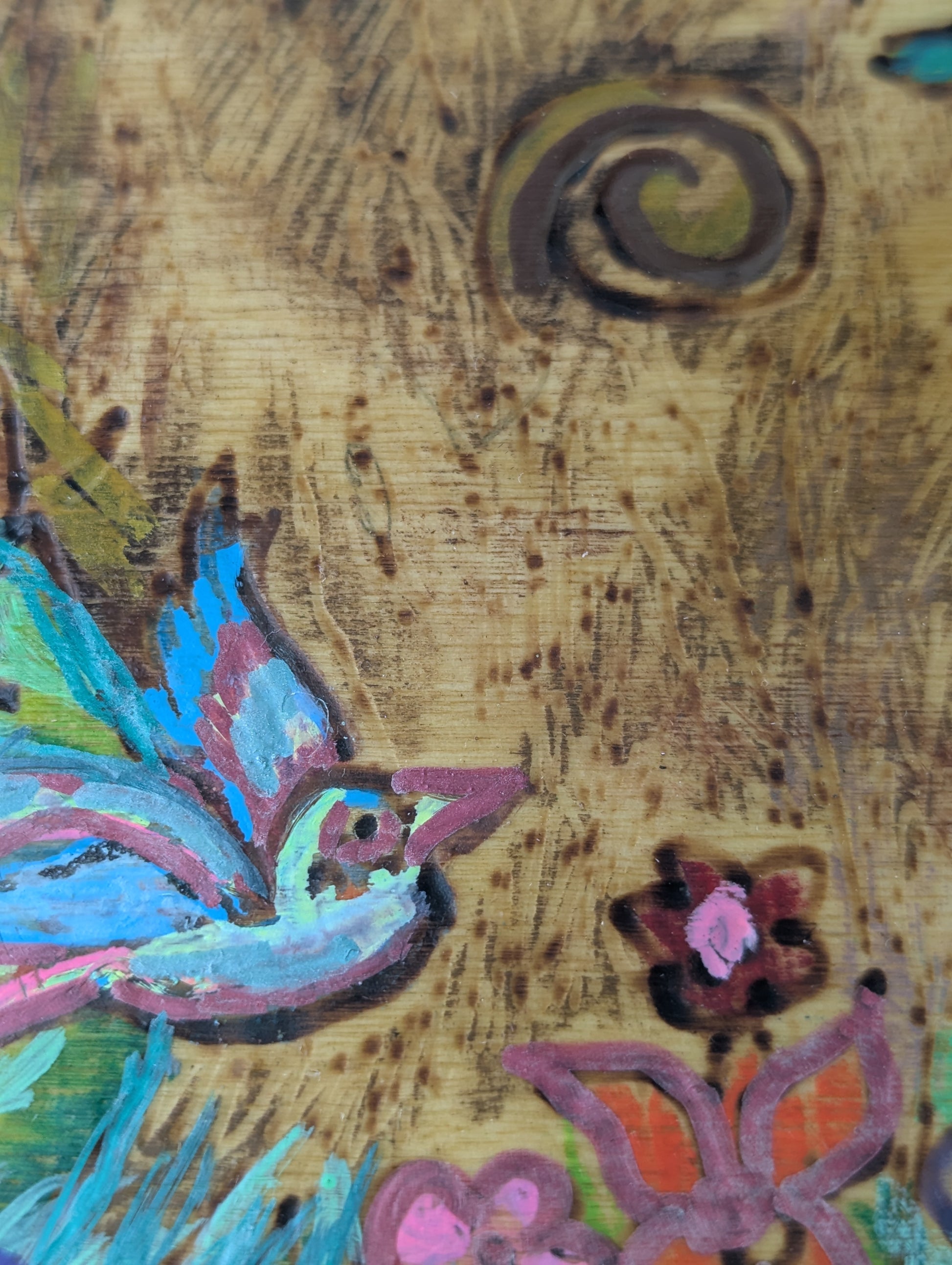 Close up of a decorative wooden box with a springtime design of a tree, birds, butterflies, and flowers 