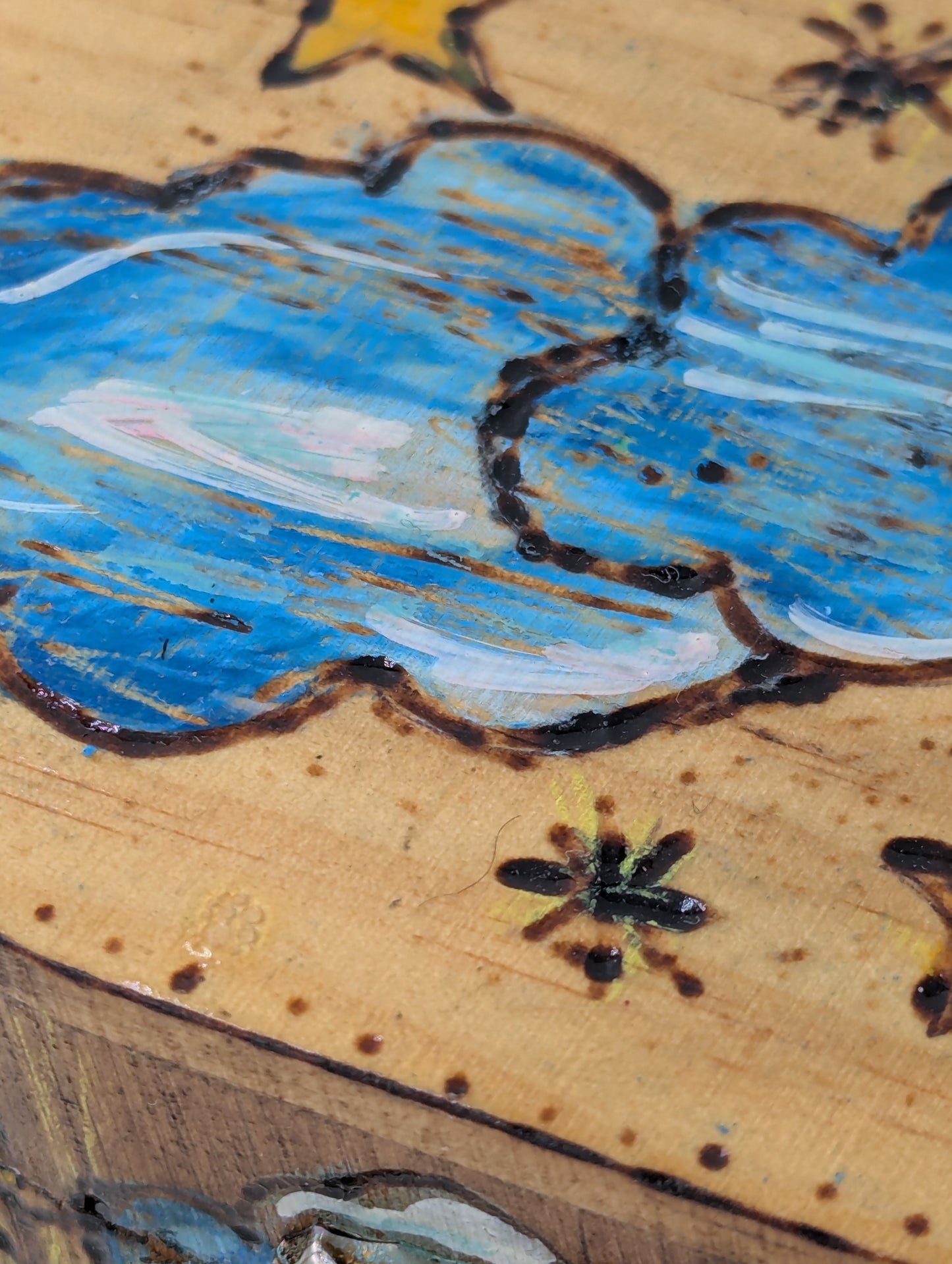 Close up of a decorative wooden box with cloud and star designs