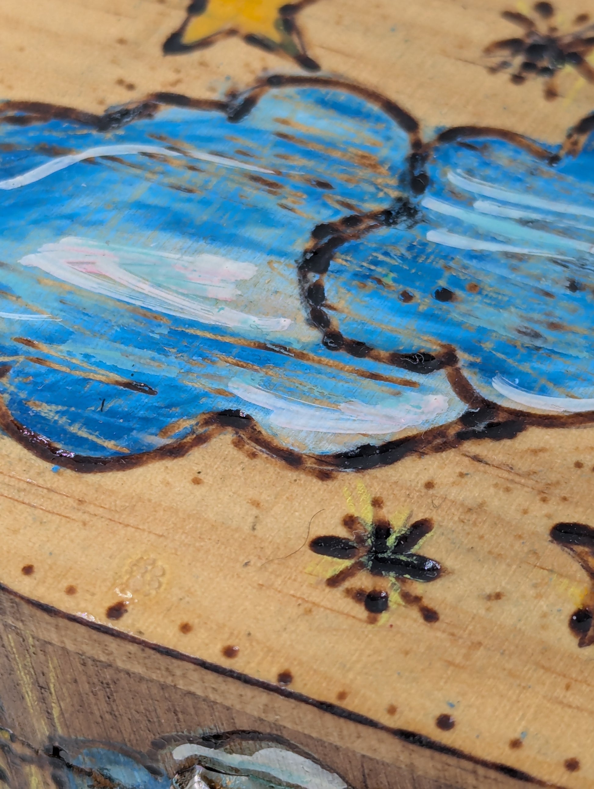Close up of a decorative wooden box with cloud and star designs