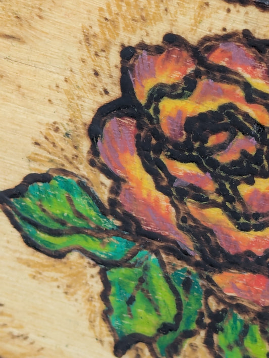 Close up of a retro suitcase shaped decorative wooden box with a painted rose design 