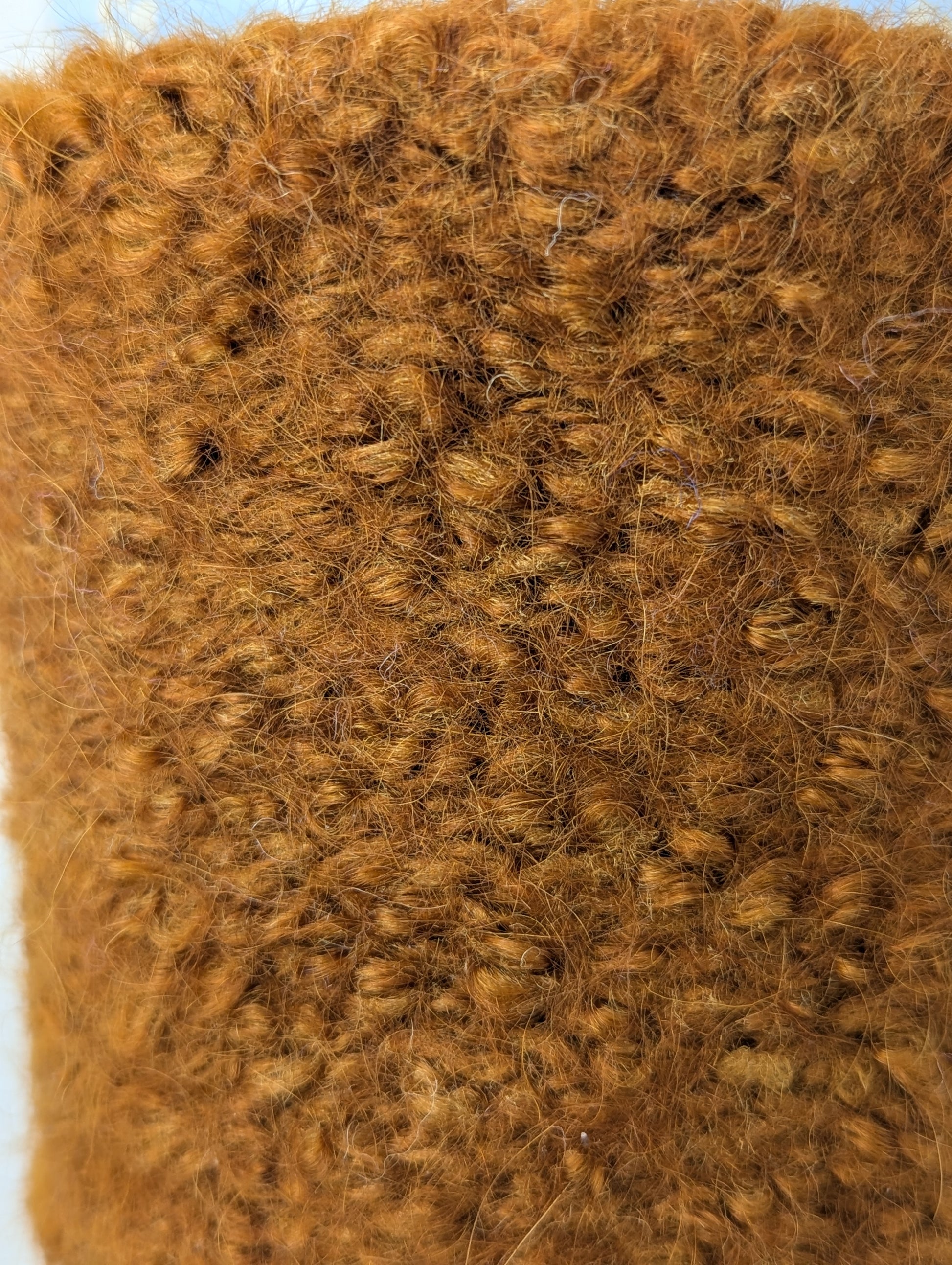 Close-up of a brown knitted and felted mug cozy