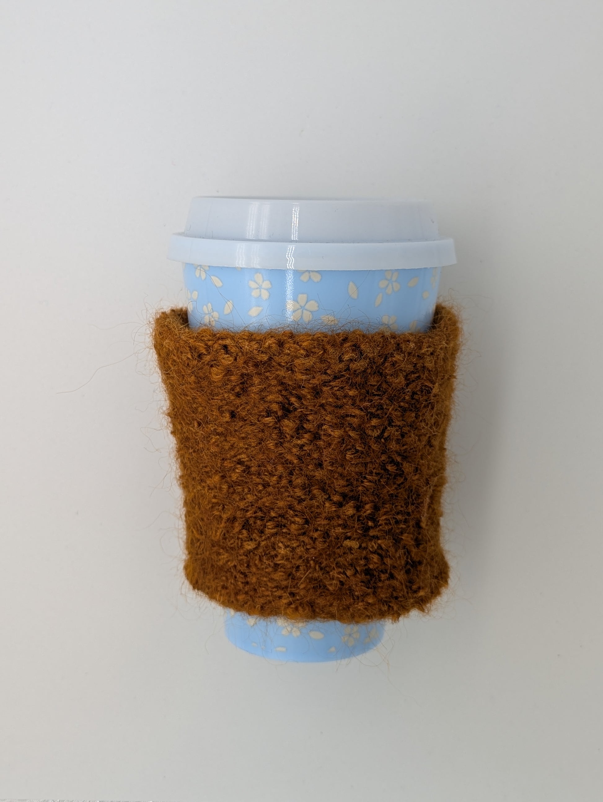 Brown knitted and felted mug cozy