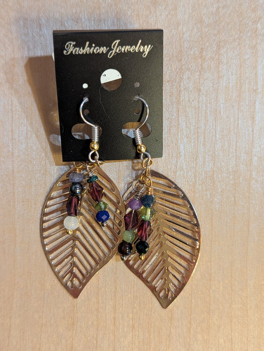 Dangle earrings on silver hooks with gold cut out leaves  accented with two strands of multicolor beads. 
