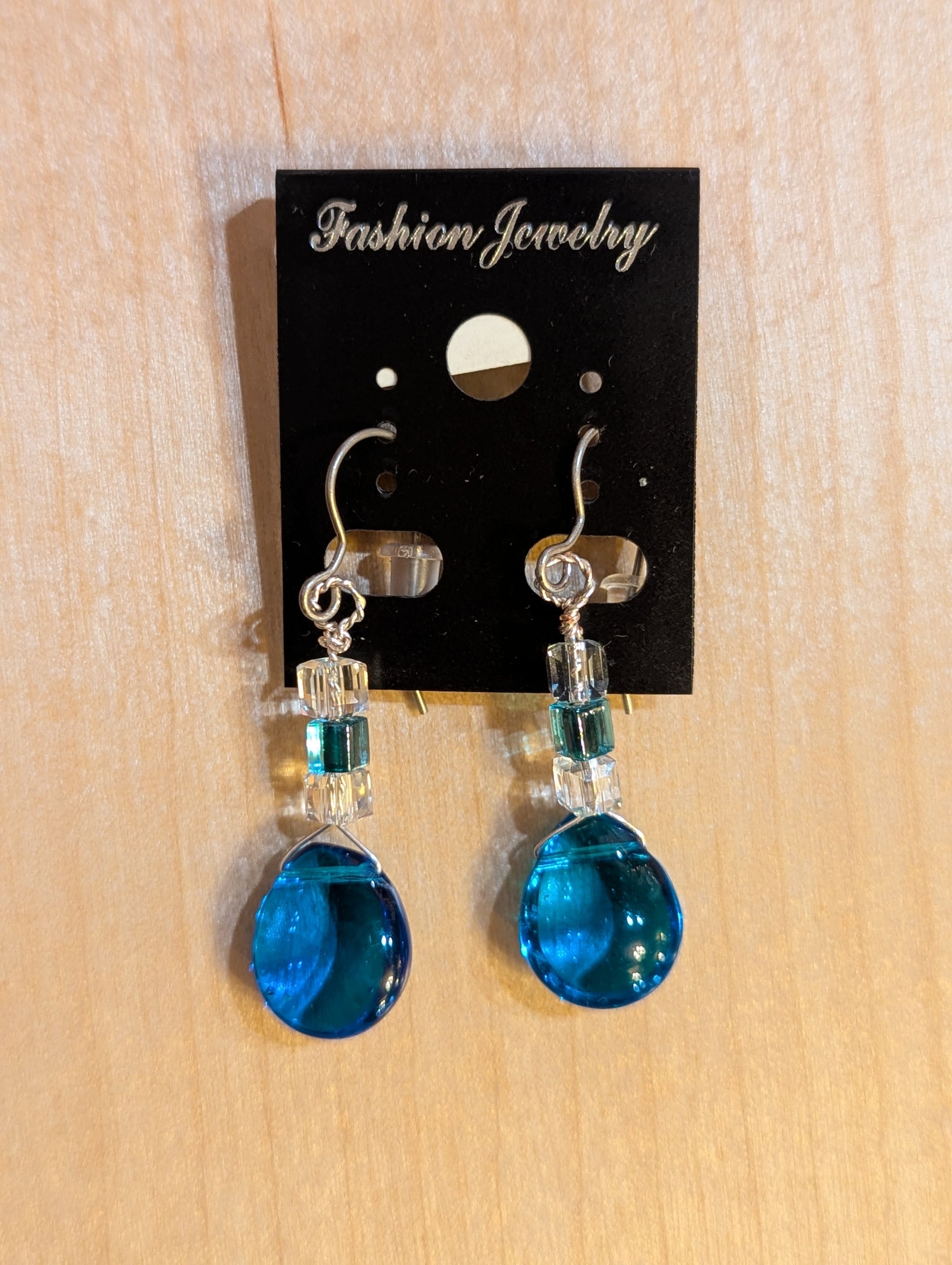 Dangle earrings on silver hooks. clear and blue Swarovski crystals lead down to a luminous smooth blue crystal droplet.