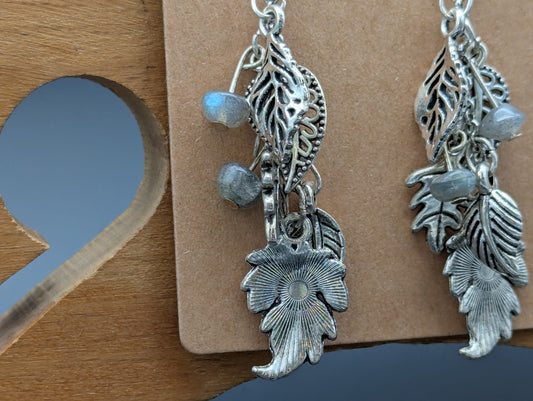 Close up of silver leaf earrings with labradorite gemstone accents.