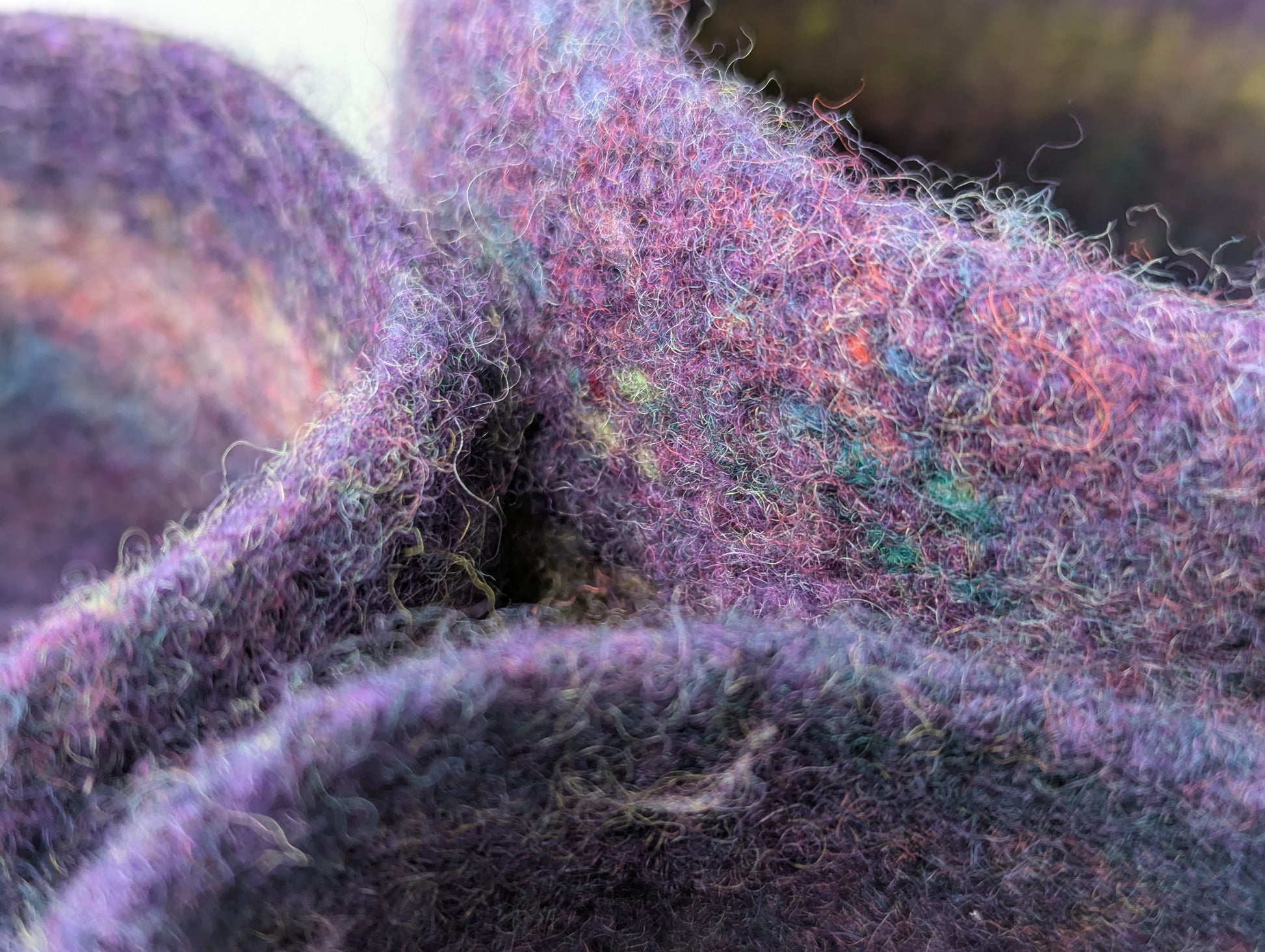 Close-up of a set of three felted bowls in colors reminiscent of Hellebore flowers