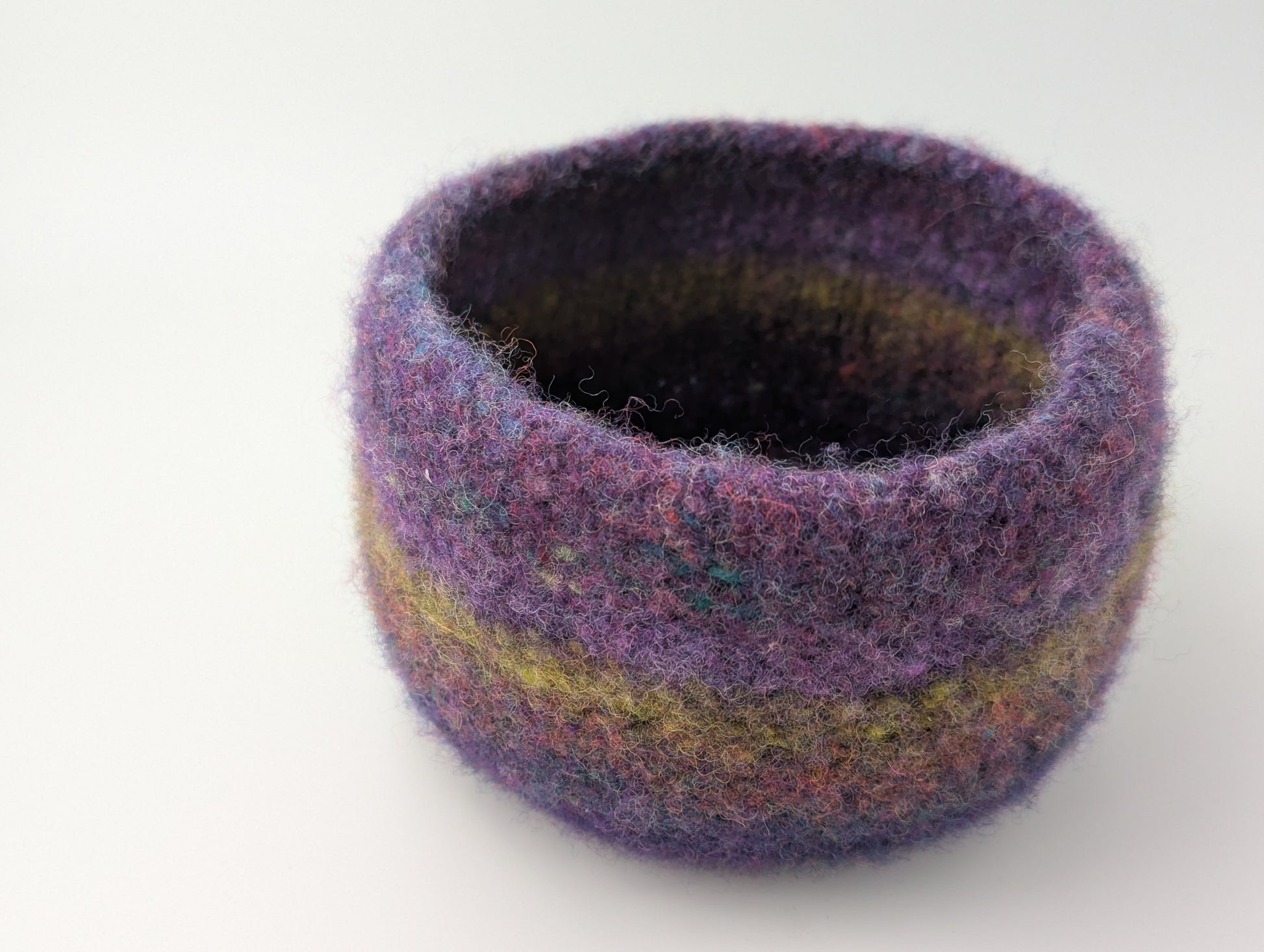 One bowl in a set of three felted bowls in colors reminiscent of Hellebore flowers