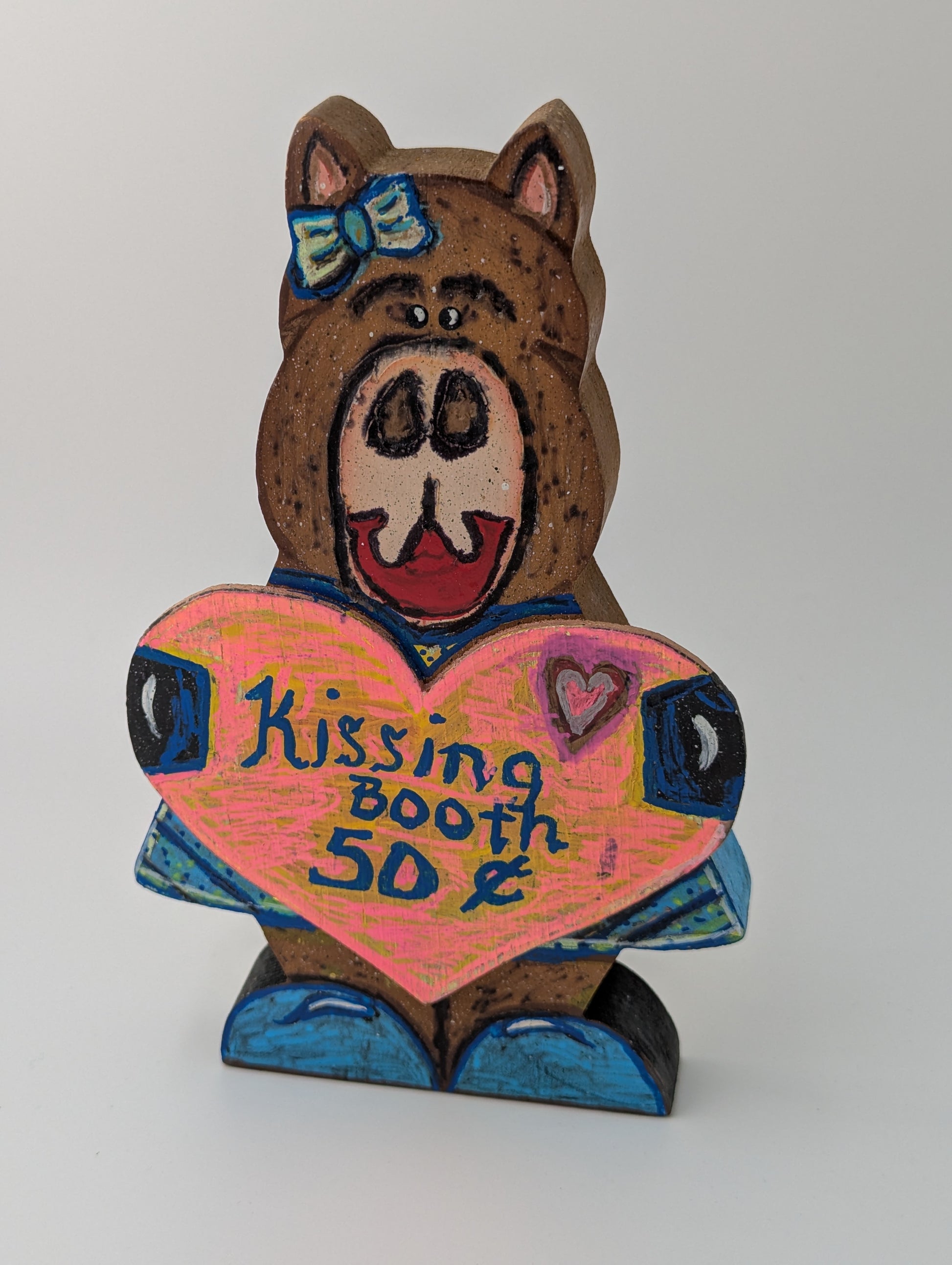 Wooden bear figurine with a heart-shaped sign saying 'Kissing Booth 50 Cents'