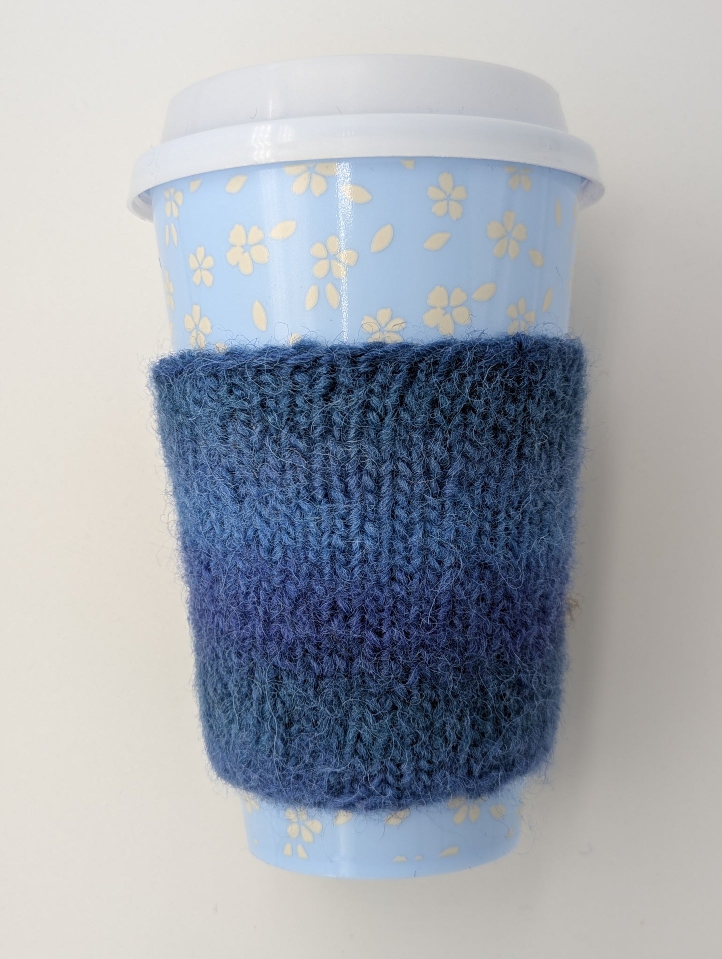 Blue knitted and felted mug cozy 