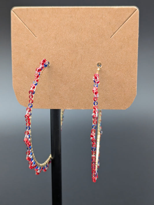 Hand crafted hoop earrings with red, clear and blue glass seed beads sewn onto hoops.