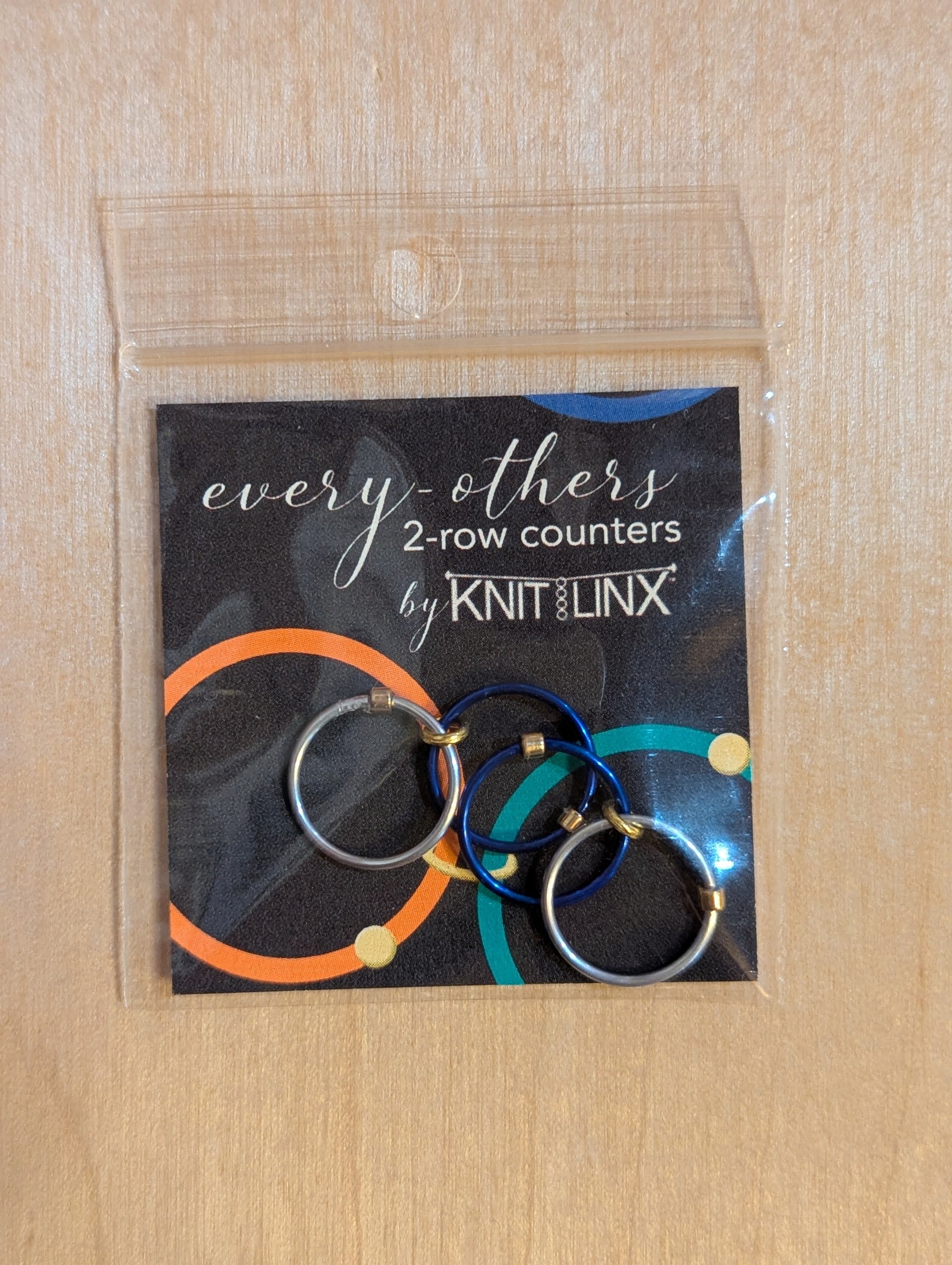 Packaged 'every-others' 2-row counters by Knit Linx for knitting needles size 9 through 13 in silver and blue colors