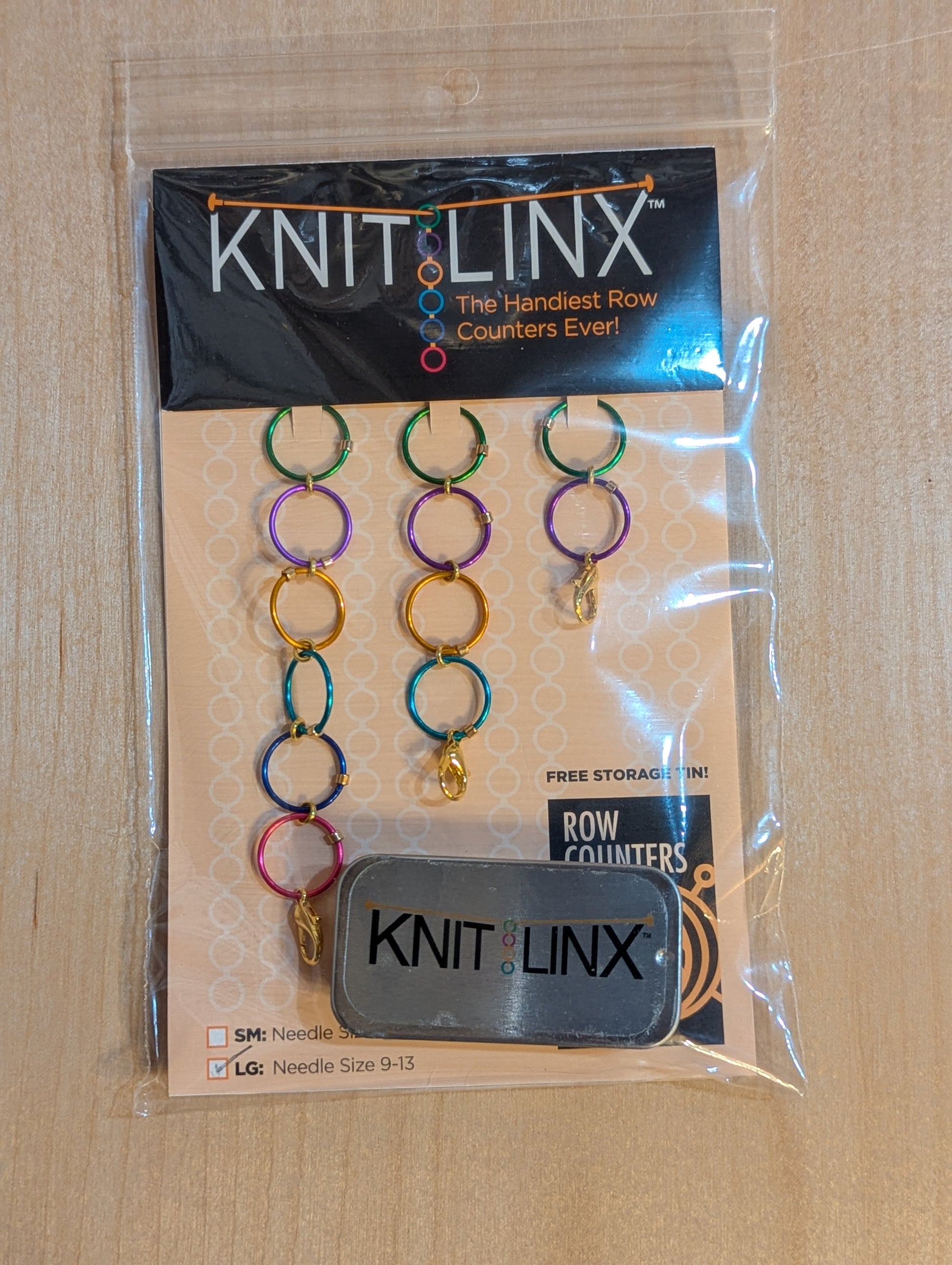 Knitting row counters in assorted chain lengths that can be connected together. For knitting needles size 9 through 13. Includes metal storage tin and instructions. Made of metal in assorted colors.
