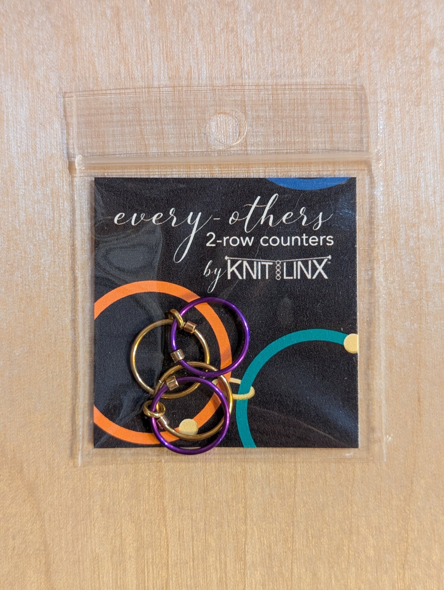 Packaged set of 'every-others' 2-row counters by KnitLinx for knitting needles size 9 through 13 in gold and purple colors