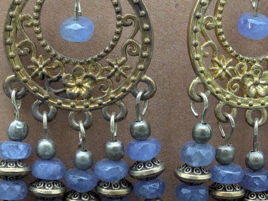 Close up of ornate antiqued gold earrings with labradorite gemstone beads.