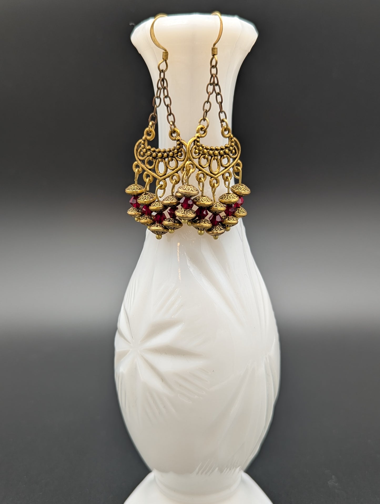 Set of elegant gold earrings with red Swarovski crystal beads.
