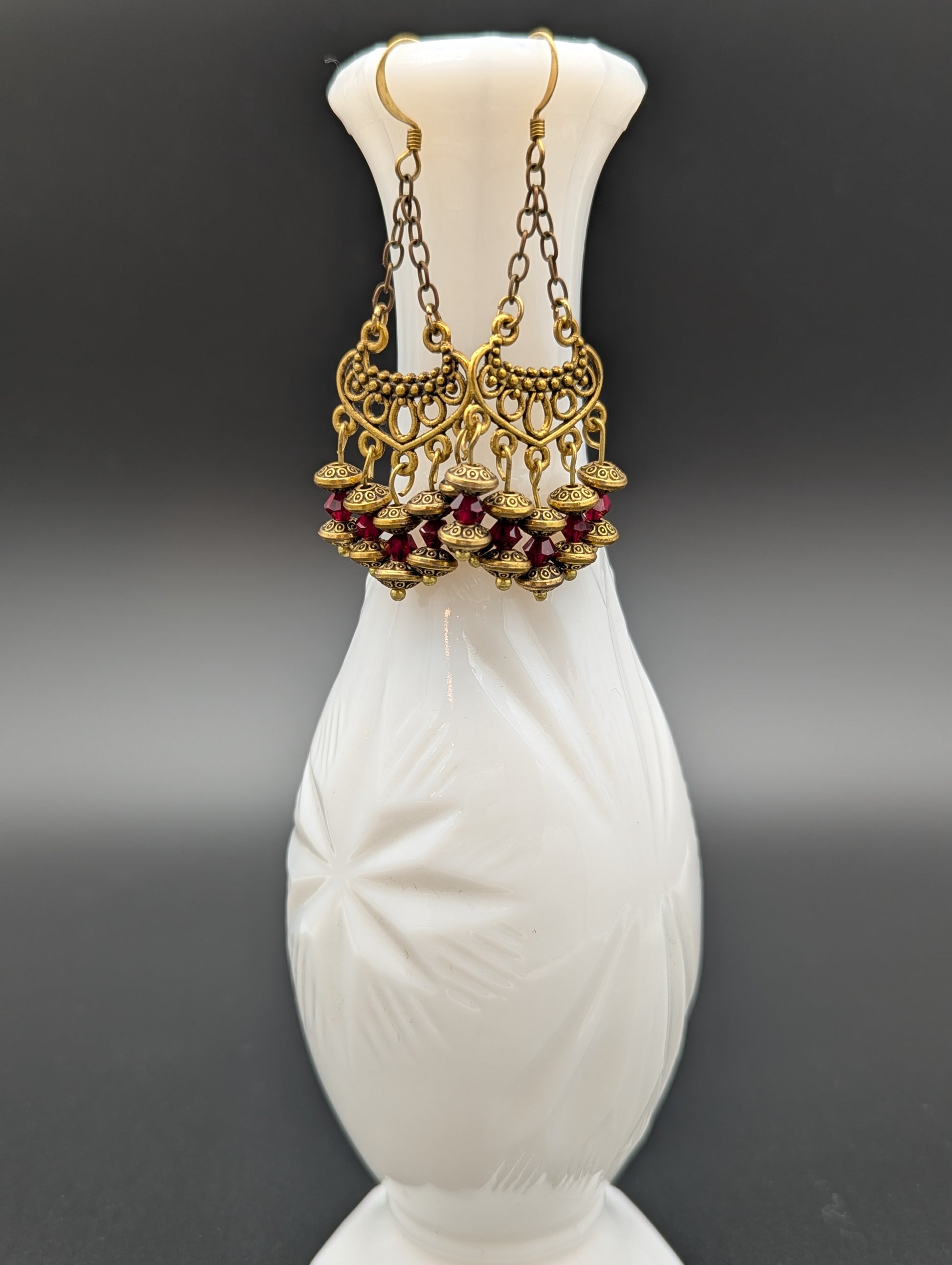 Set of elegant gold earrings with red Swarovski crystal beads.