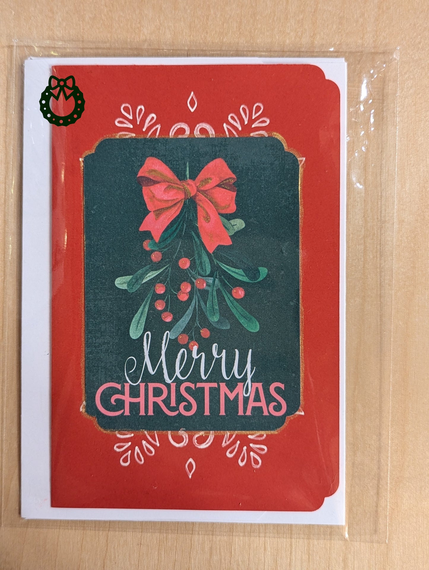 Christmas card with red bow and mistletoe design on a green background with a red border.