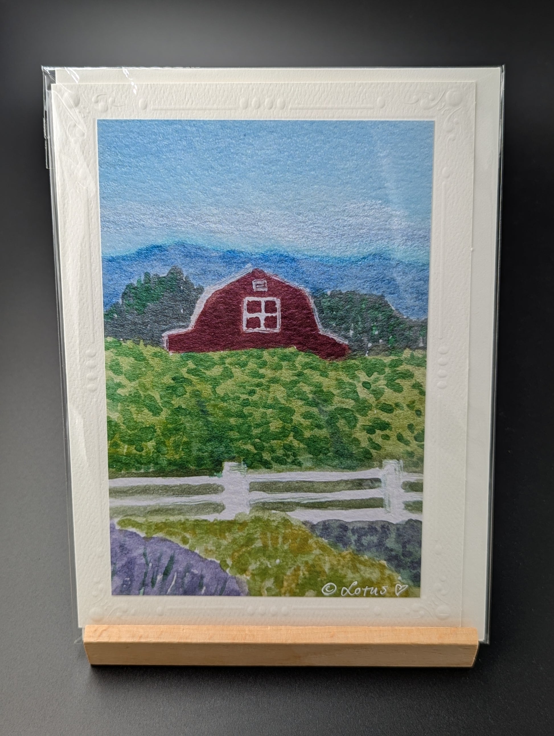 Hand drawn greeting card featuring a rural scene of a field and barn
