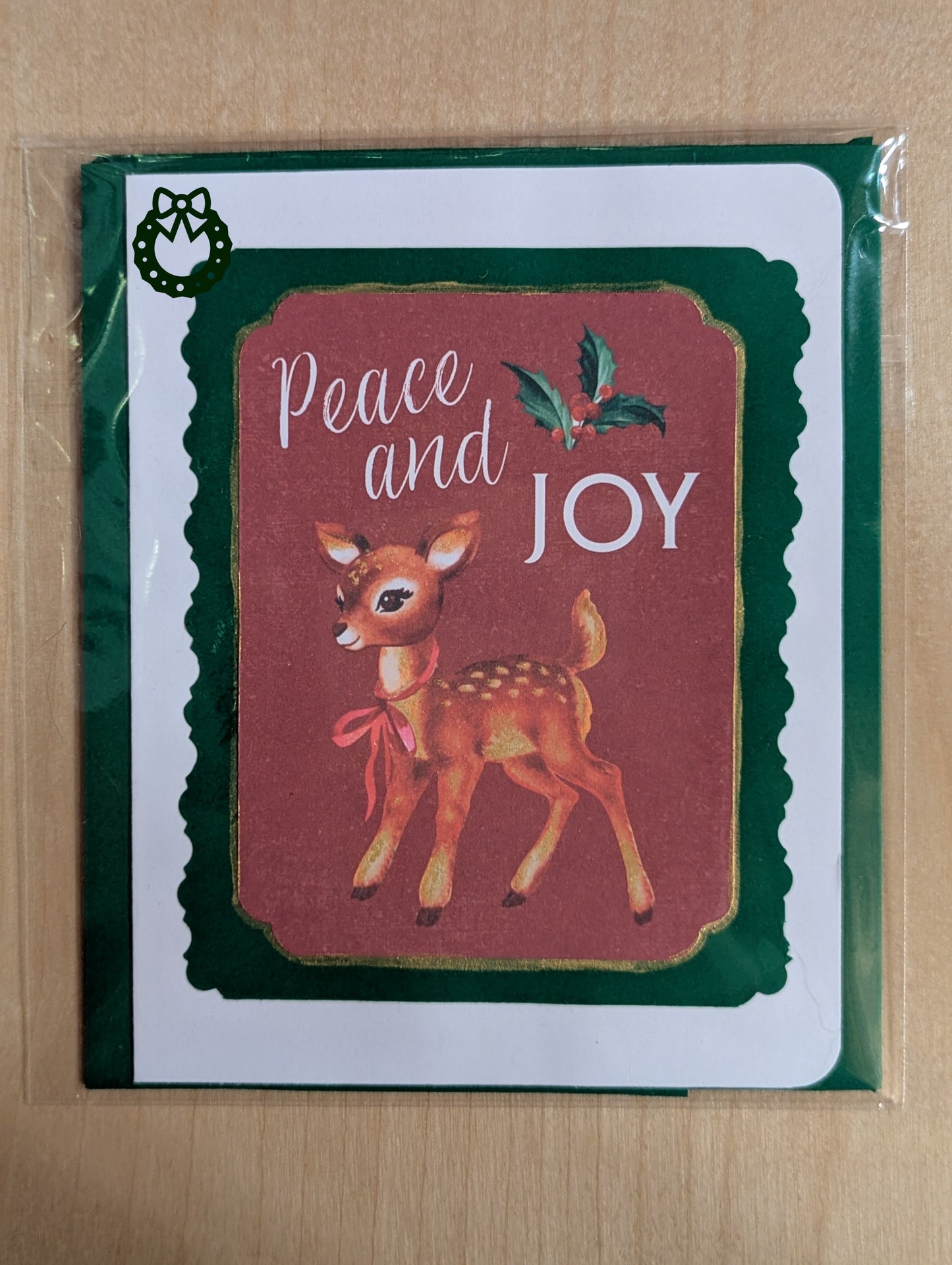 Christmas card with a deer illustration and 'Peace and Joy' text on a red background.