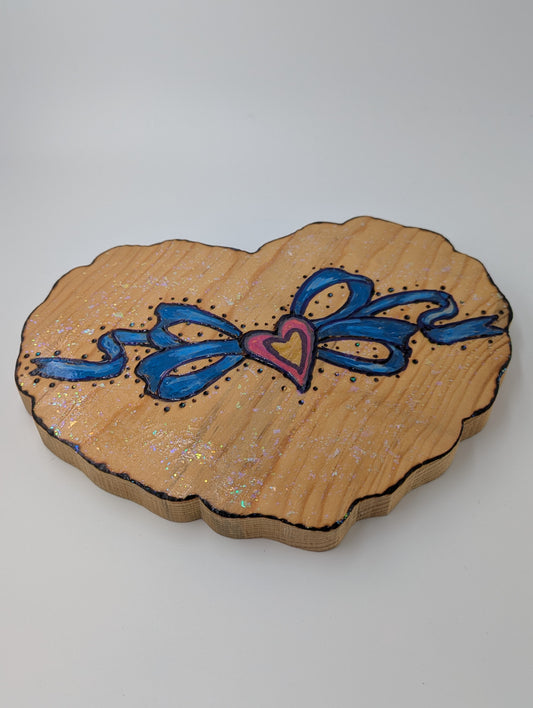 Decorative wooden heart-shaped plaque with blue and pink designs.