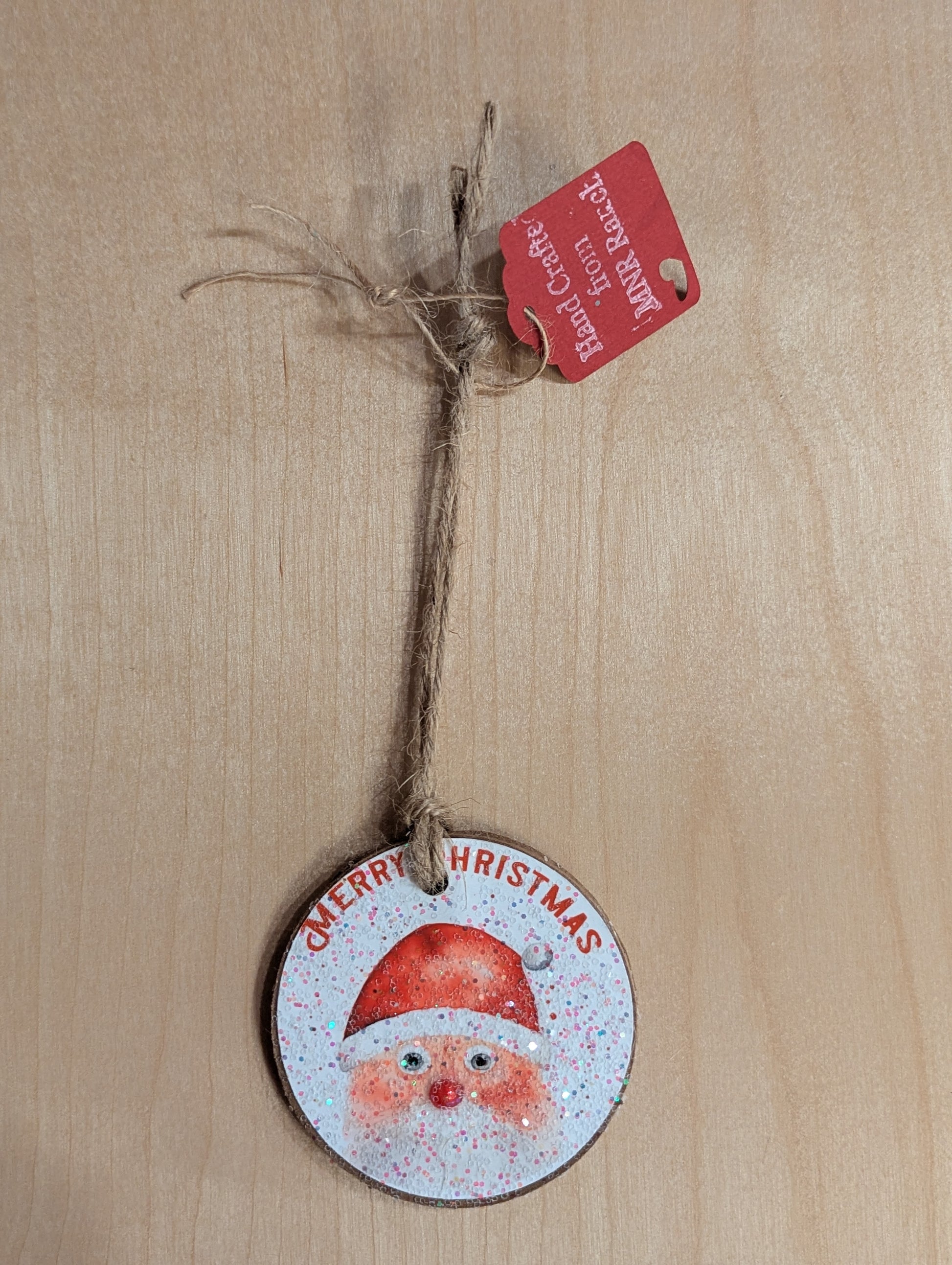 A Santa Claus ornament saying 'Merry Christmas'